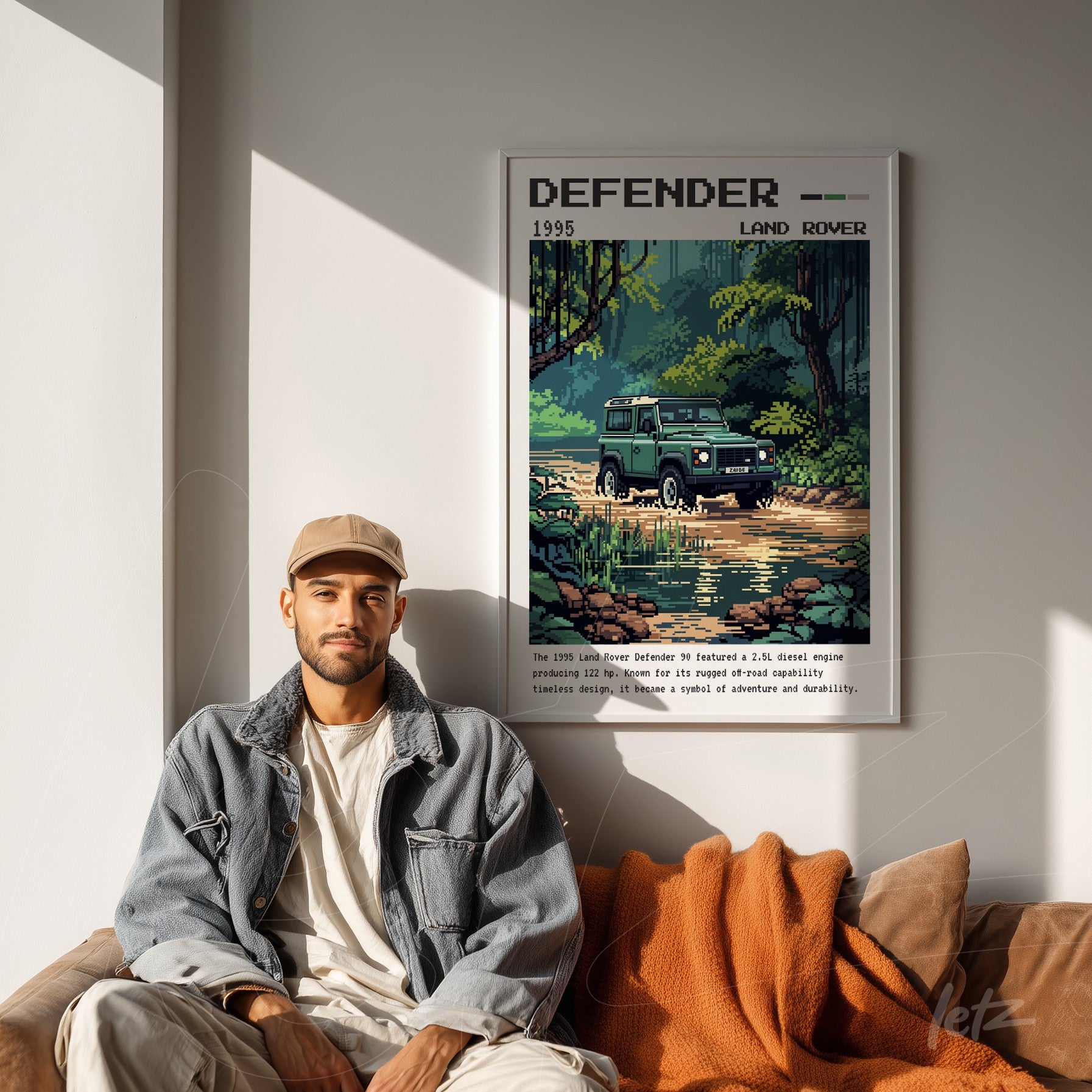 framed pixel art of Land Rover Defender displayed above a brown sofa with an orange throw blanket