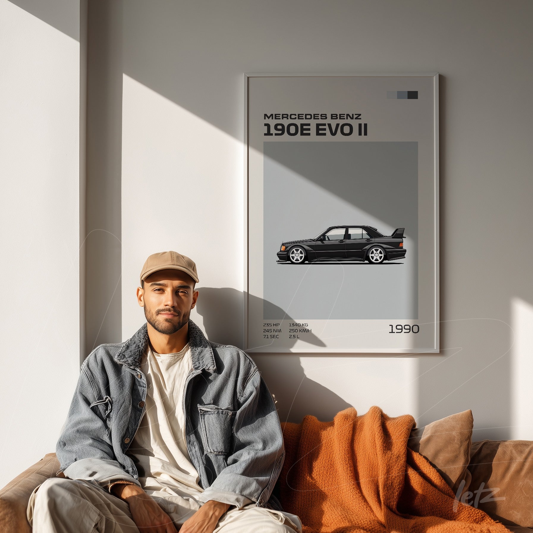 framed artwork featuring the Mercedes Benz 190E Evo II on light wall next to a man sitting on a sofa
