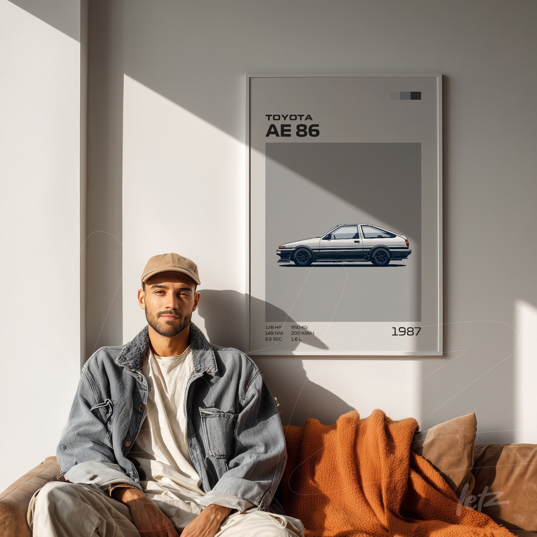 framed wall art featuring an illustration of a toyota ae 86 on a light wall with a man sitting beside it
