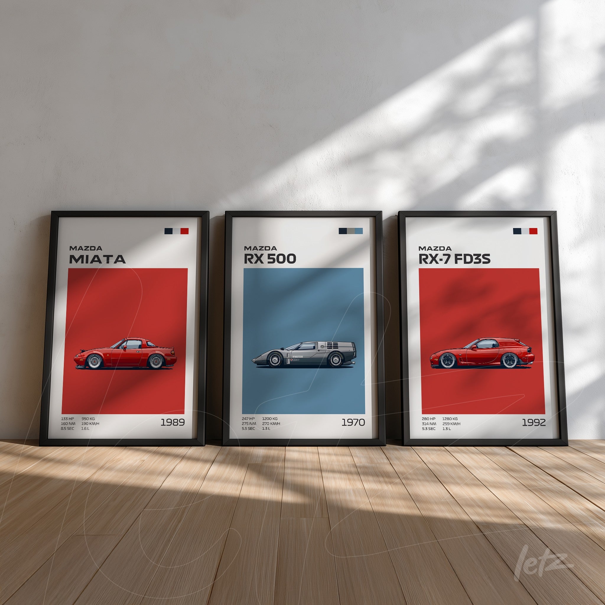composition of three framed wall art pieces featuring vintage Mazda cars, black frames for each artwork, displayed in a light wooden floor setting with white walls
