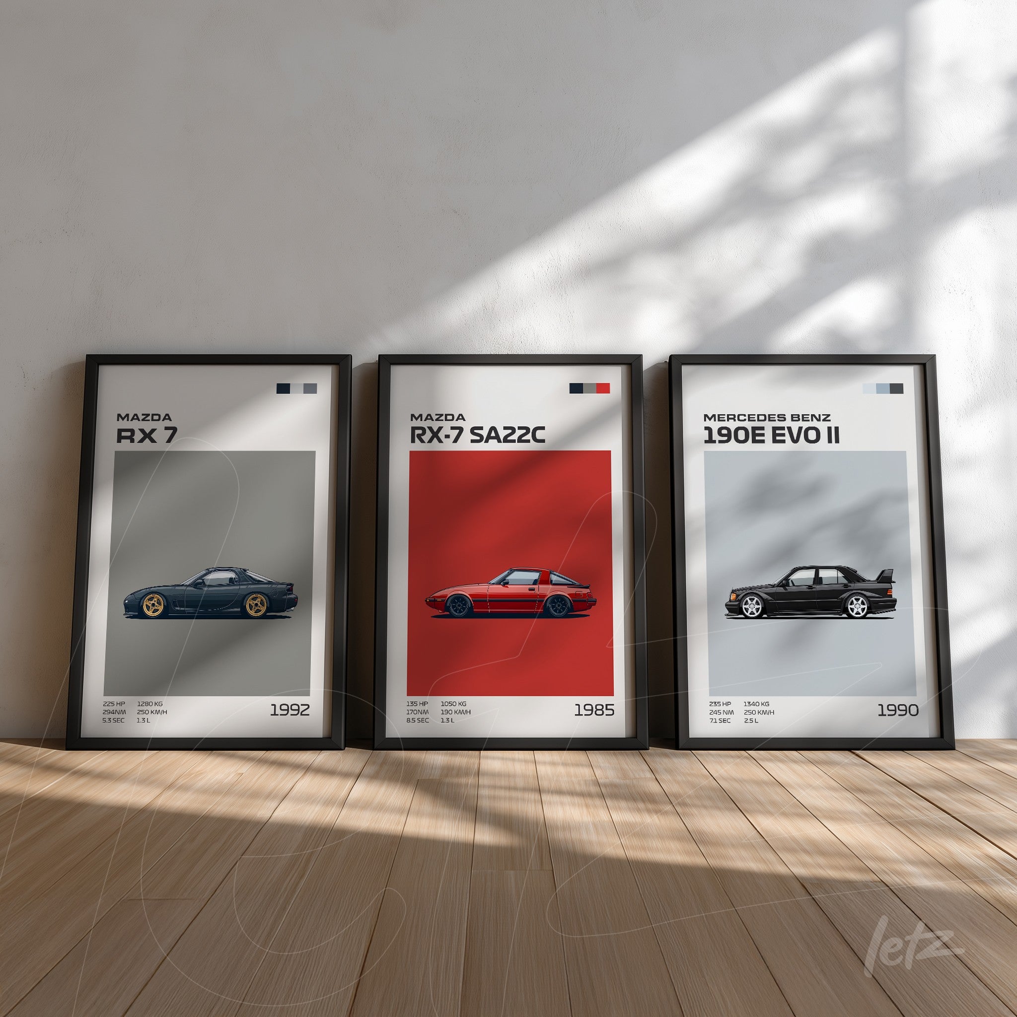 series of framed wall art featuring classic car illustrations, showcasing the 1992 Mazda RX-7, the 1985 Mazda RX-7 SA22C on red background, and the 1990 Mercedes-Benz 190E EVO II on gray background, placed on wooden floor