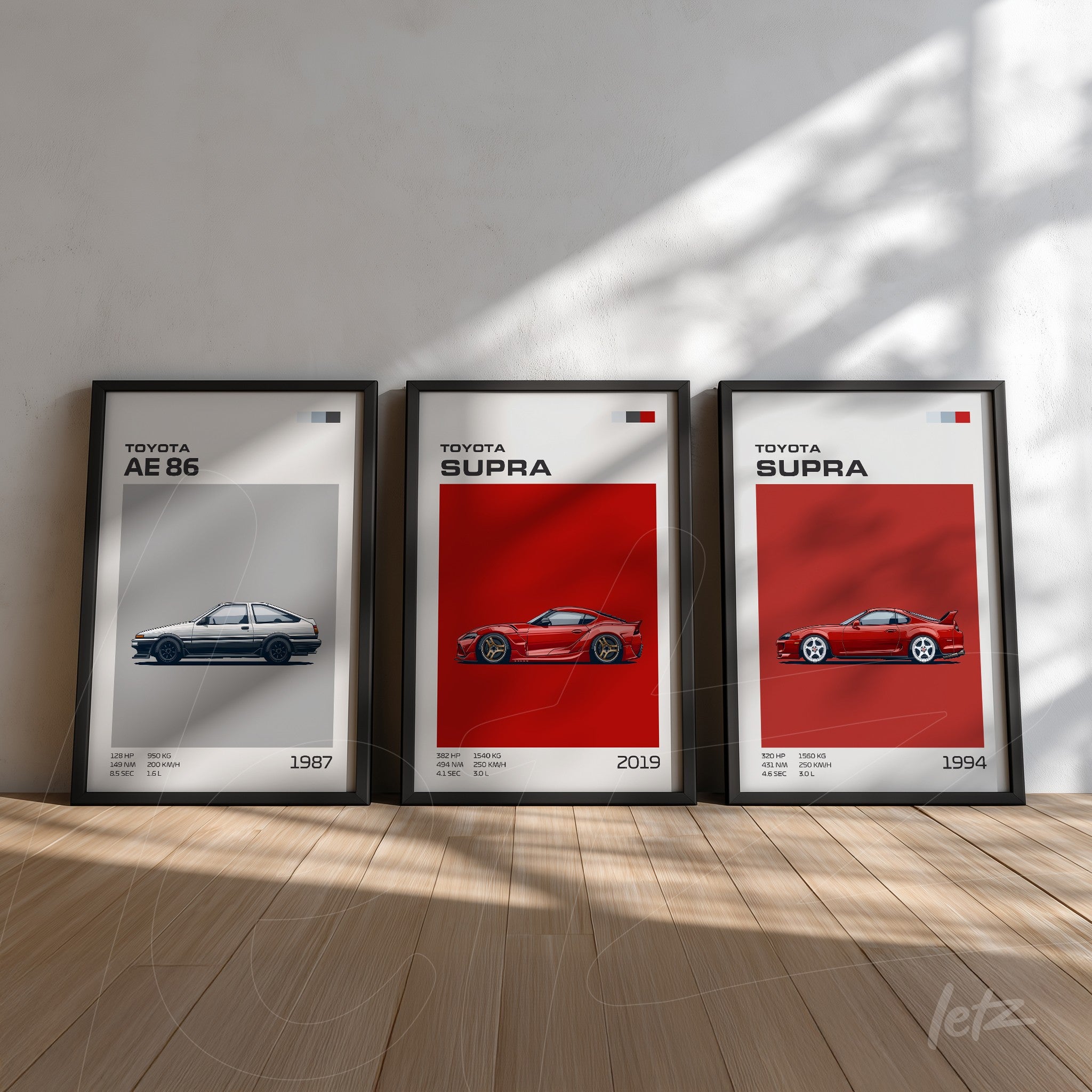 set of framed artworks featuring illustrations of Toyota cars, including AE 86 from 1987, Supra from 2019, and Supra from 1994, displayed on a light wall