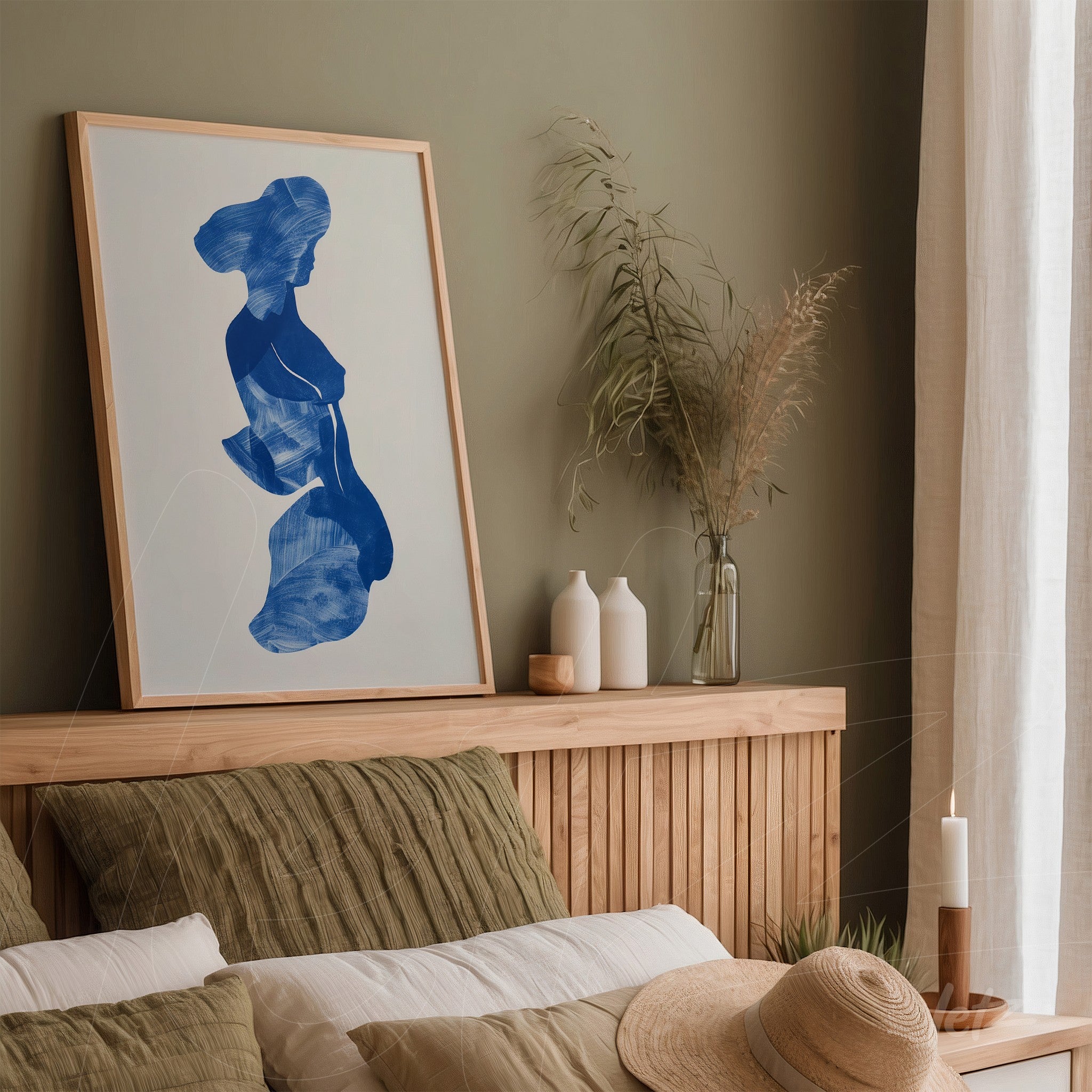 framed artwork with abstract blue design displayed above a wooden headboard in a minimalist decor setting