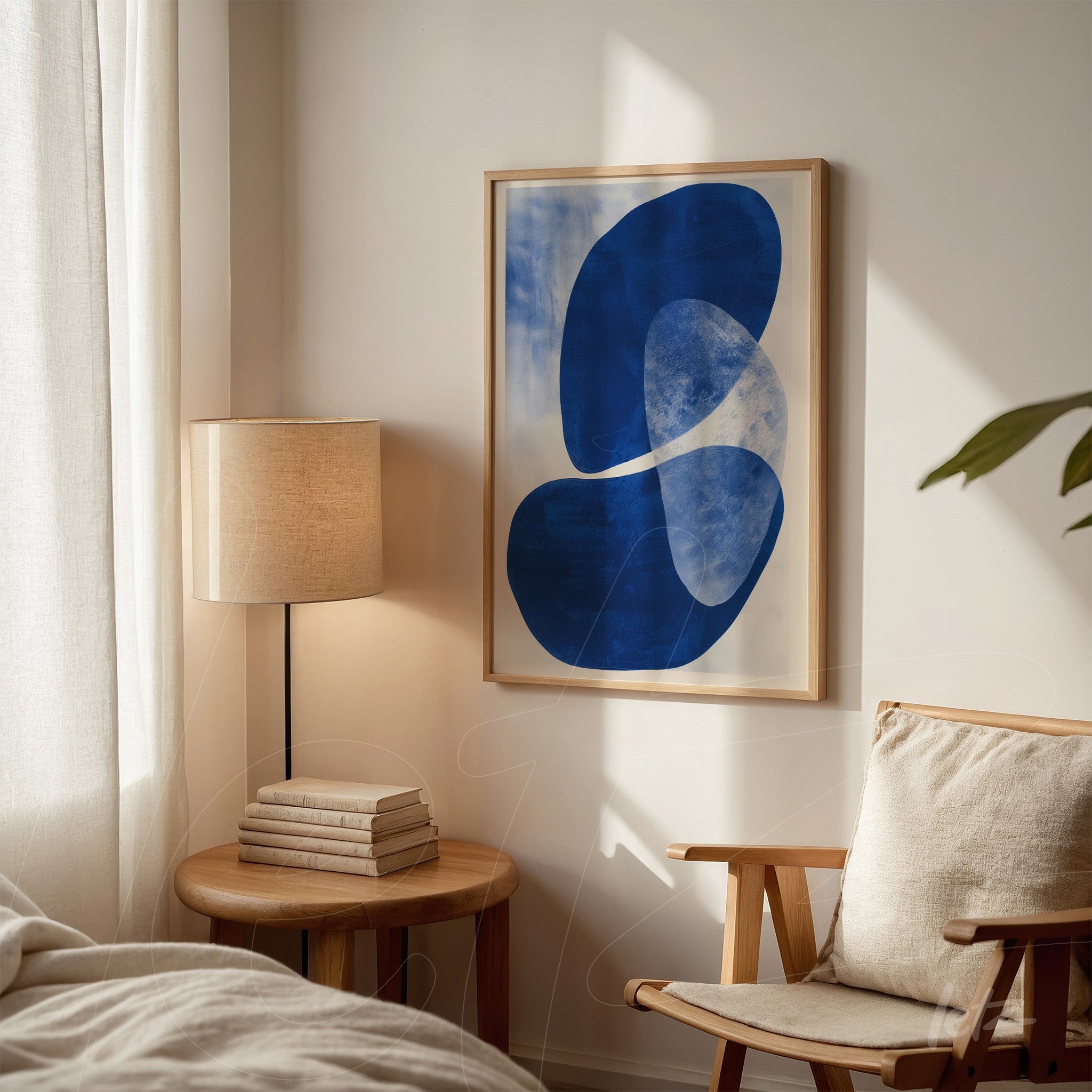 framed abstract wall art in blue displayed on a neutral wall next to a wooden side table