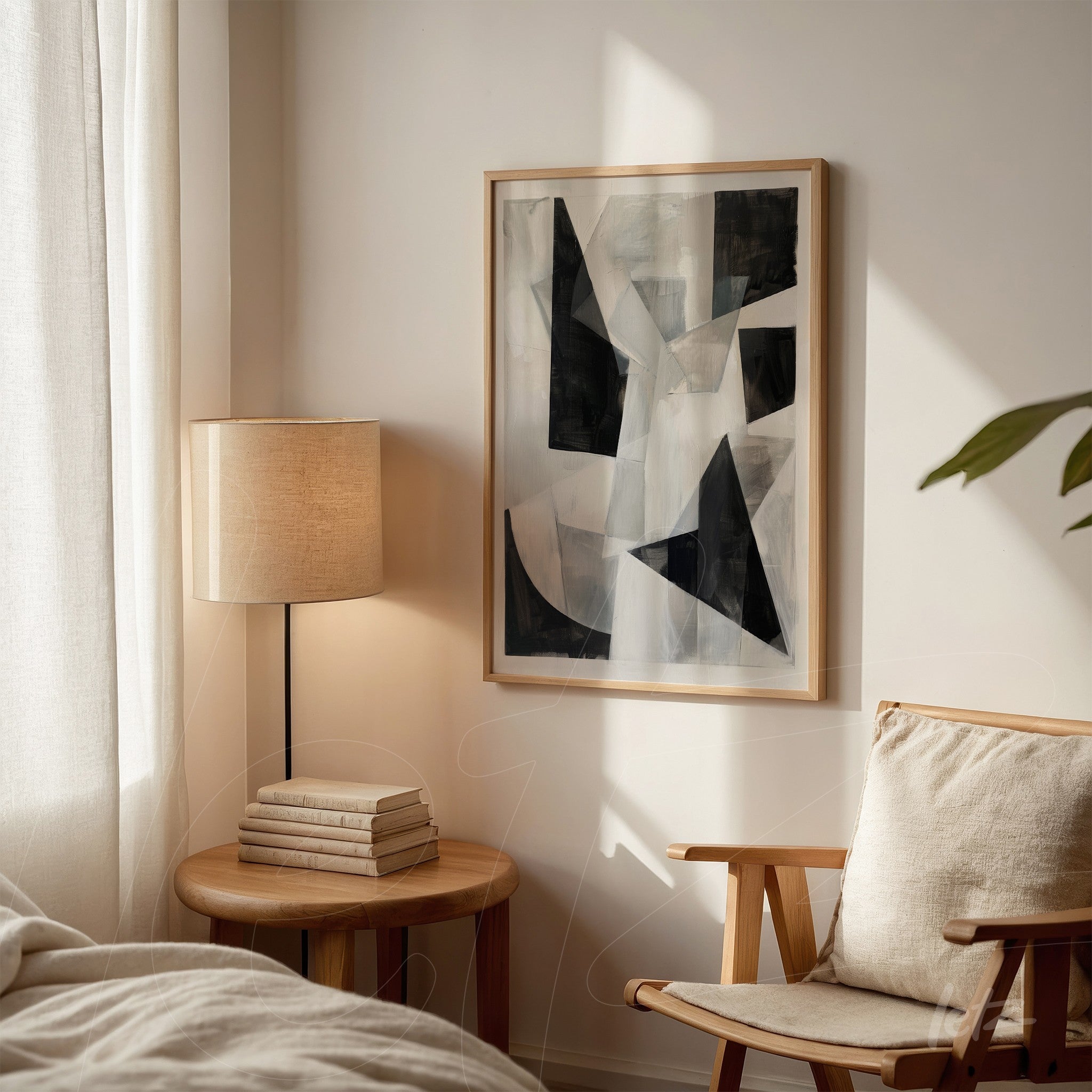 abstract artwork featuring geometric shapes in black and gray tones in a light wooden frame displayed in a well-lit setting next to a table lamp