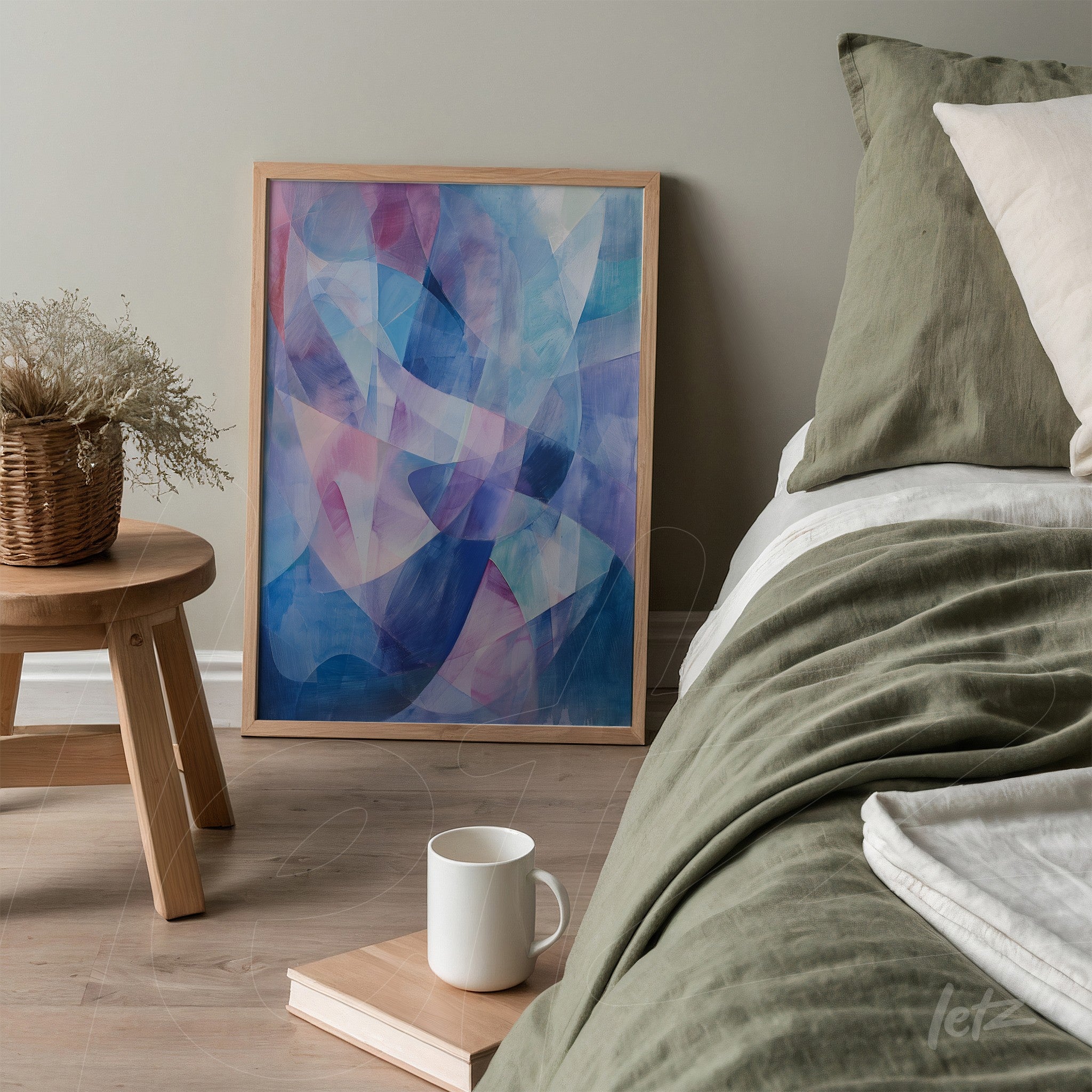 abstract framed wall art with shades of blue and pink leaning next to a bed in a modern bedroom