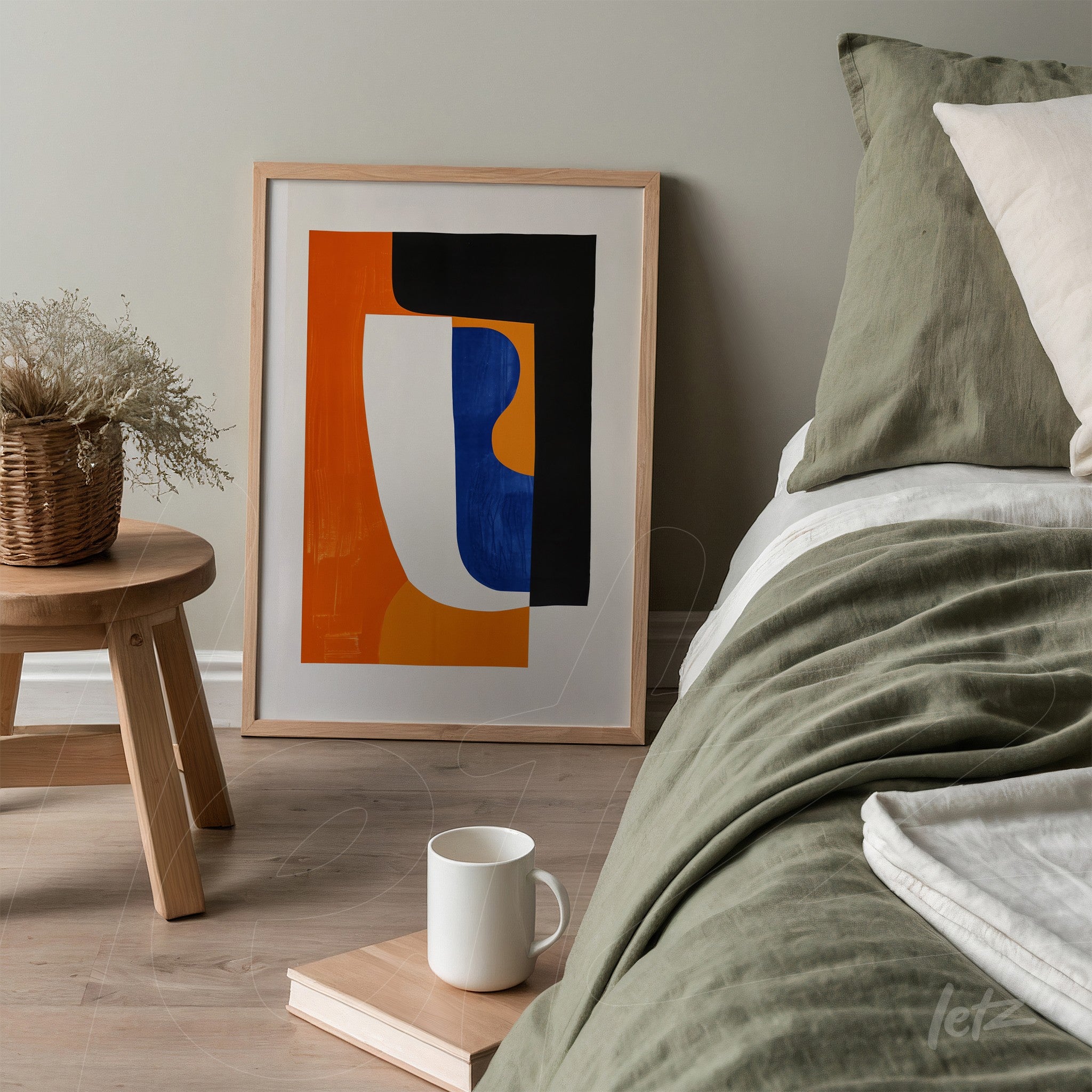 framed abstract artwork with light frame displayed next to a bed with green bedding and light pillows in a minimalist setting