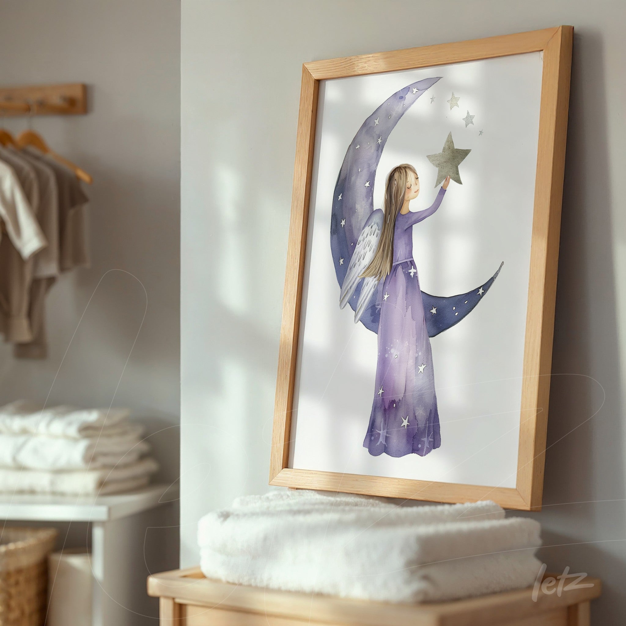 framed wall art of a girl with wings holding a star, set against a crescent moon on a light background with a light wood frame
