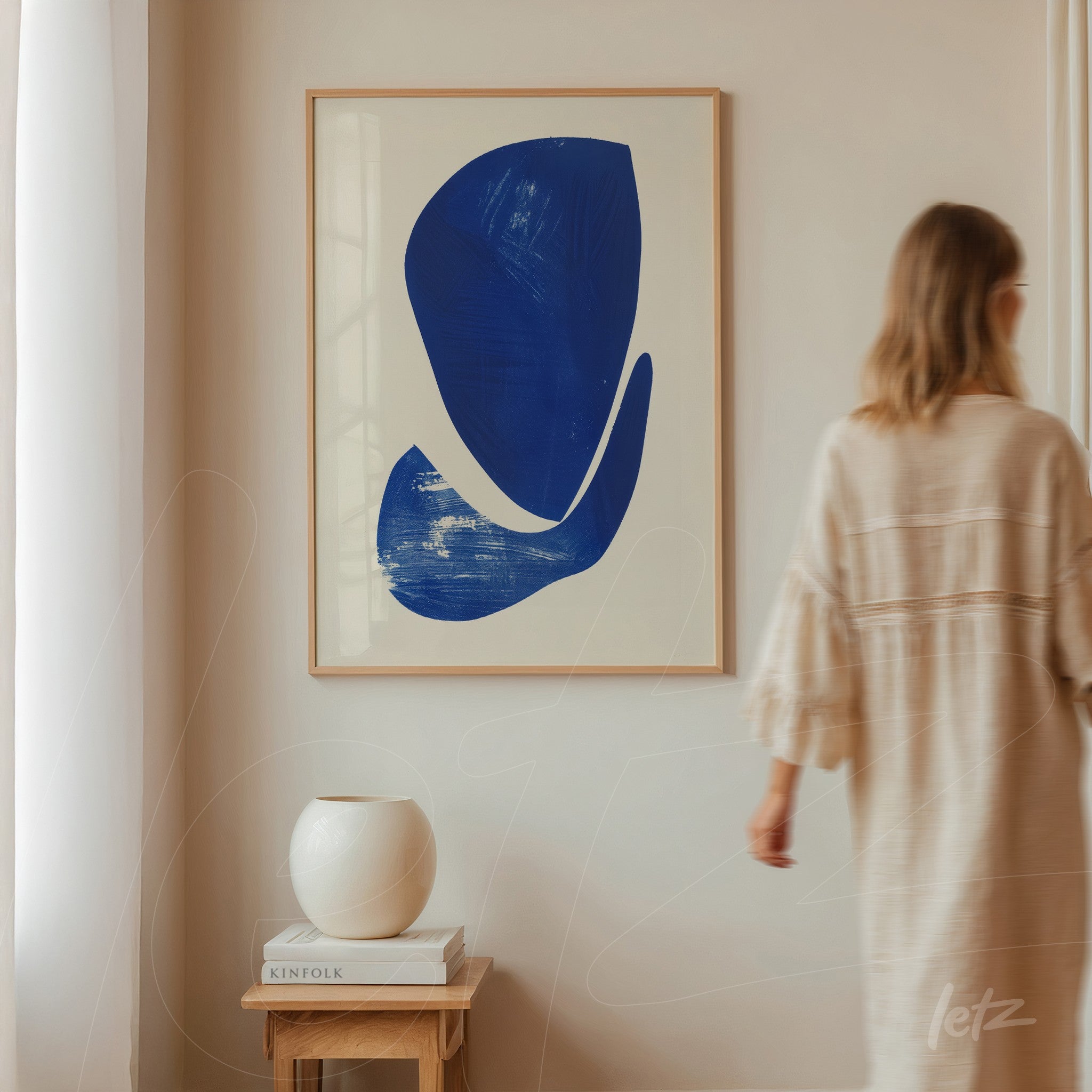 framed wall art featuring abstract blue shapes on white background displayed in a minimalist interior