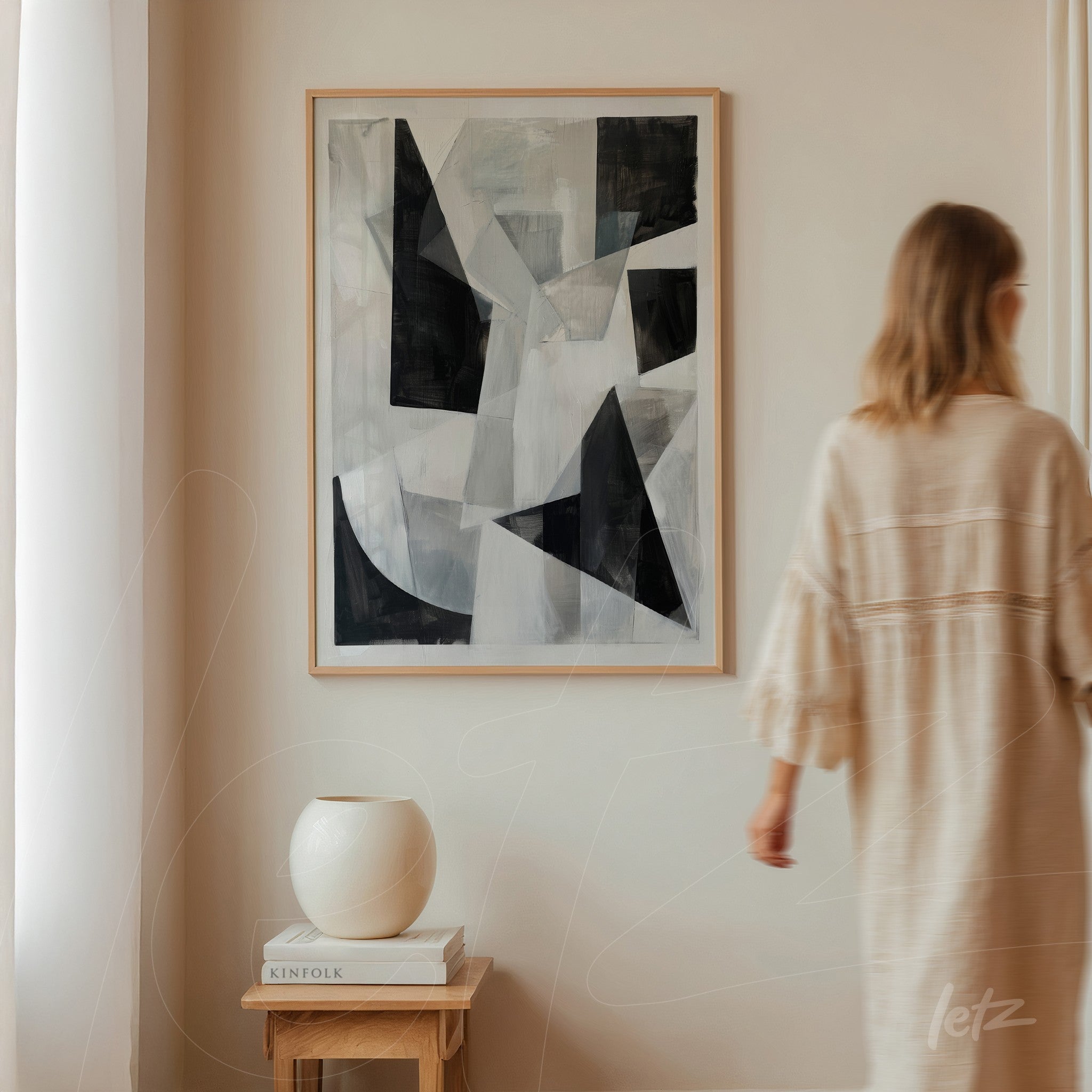 modern abstract wall art in black and white framed in light wood displayed on a light wall