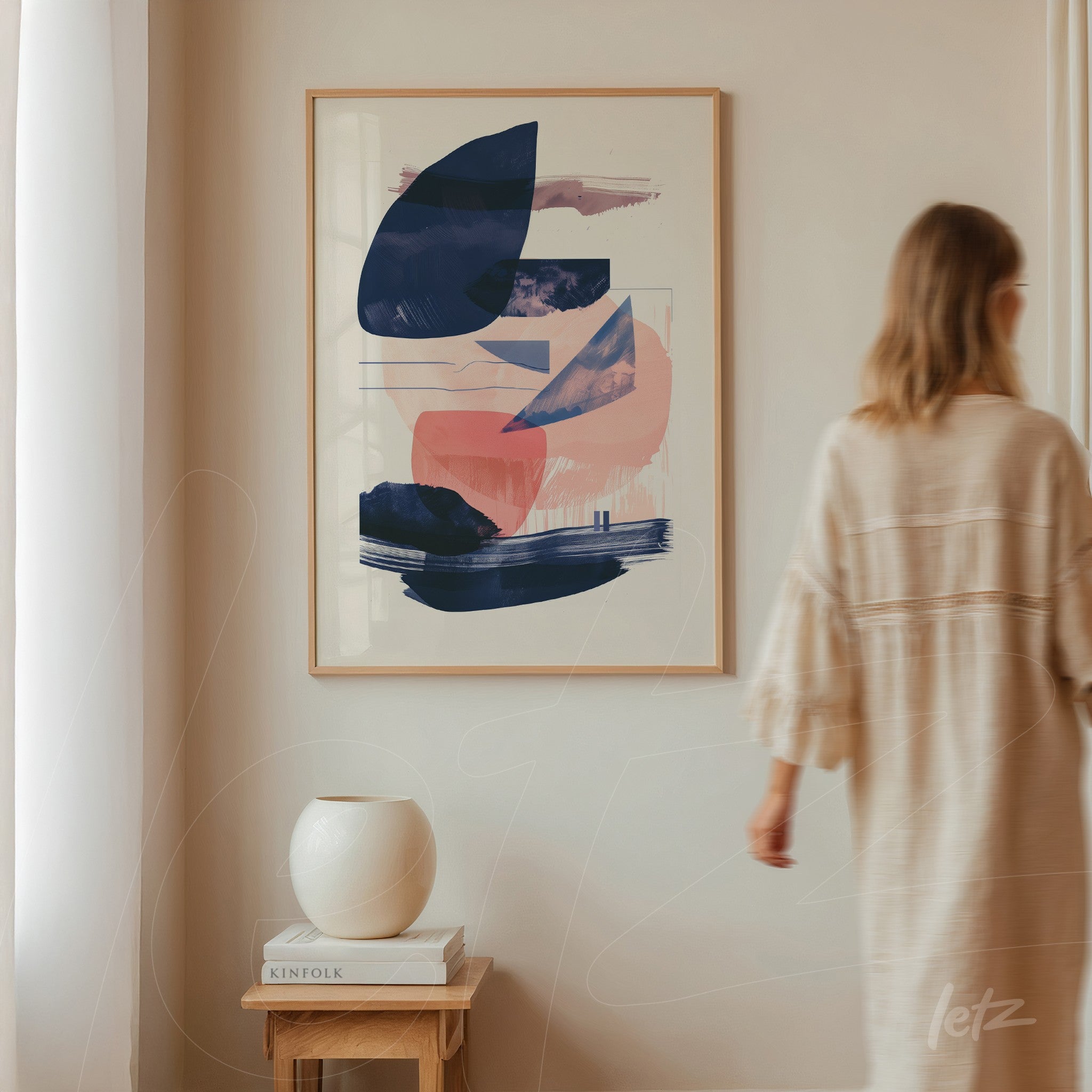 framed abstract art in shades of blue and pink displayed on a neutral wall
