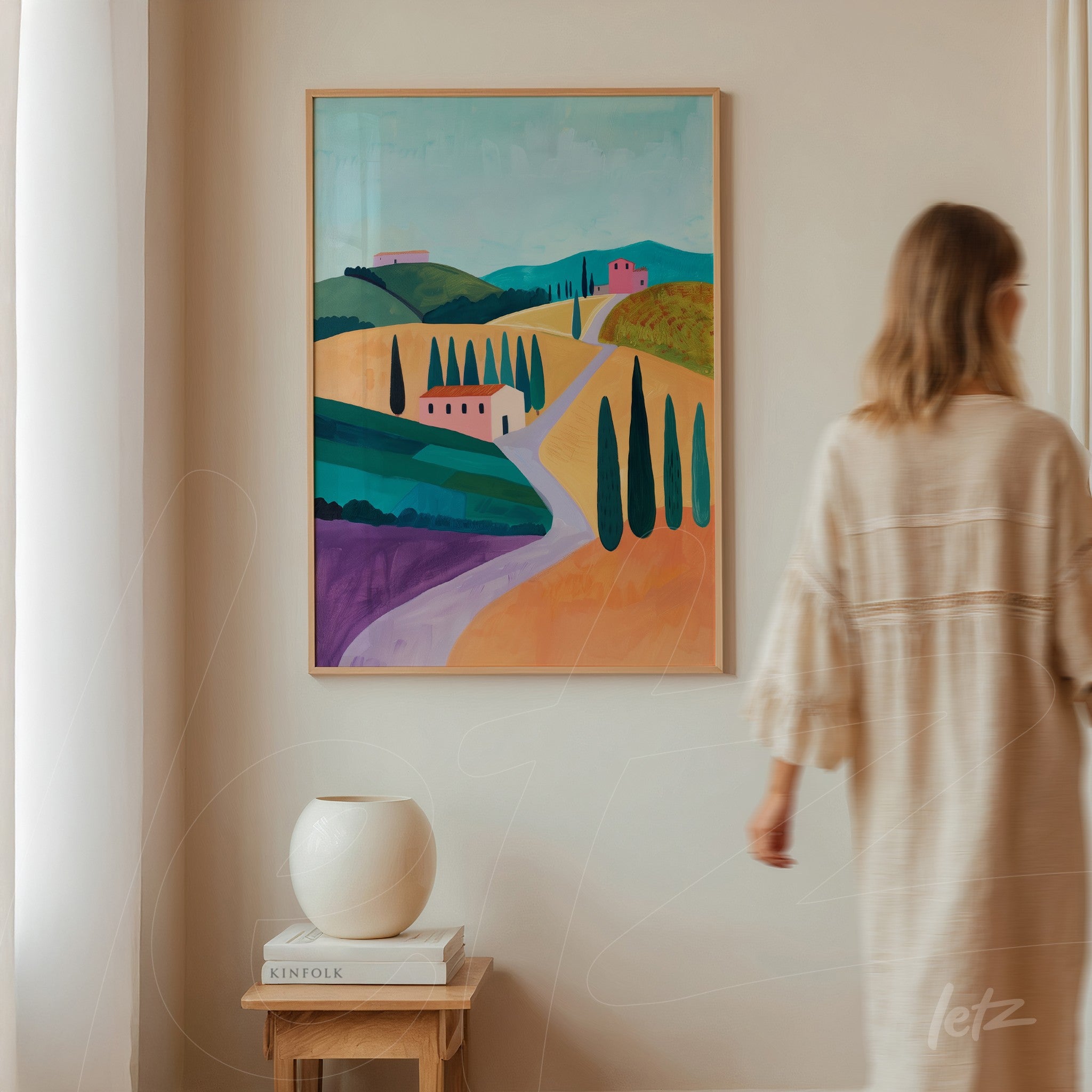 large framed art featuring a vibrant landscape of hills and cypress trees with light wood frame displayed on a neutral wall