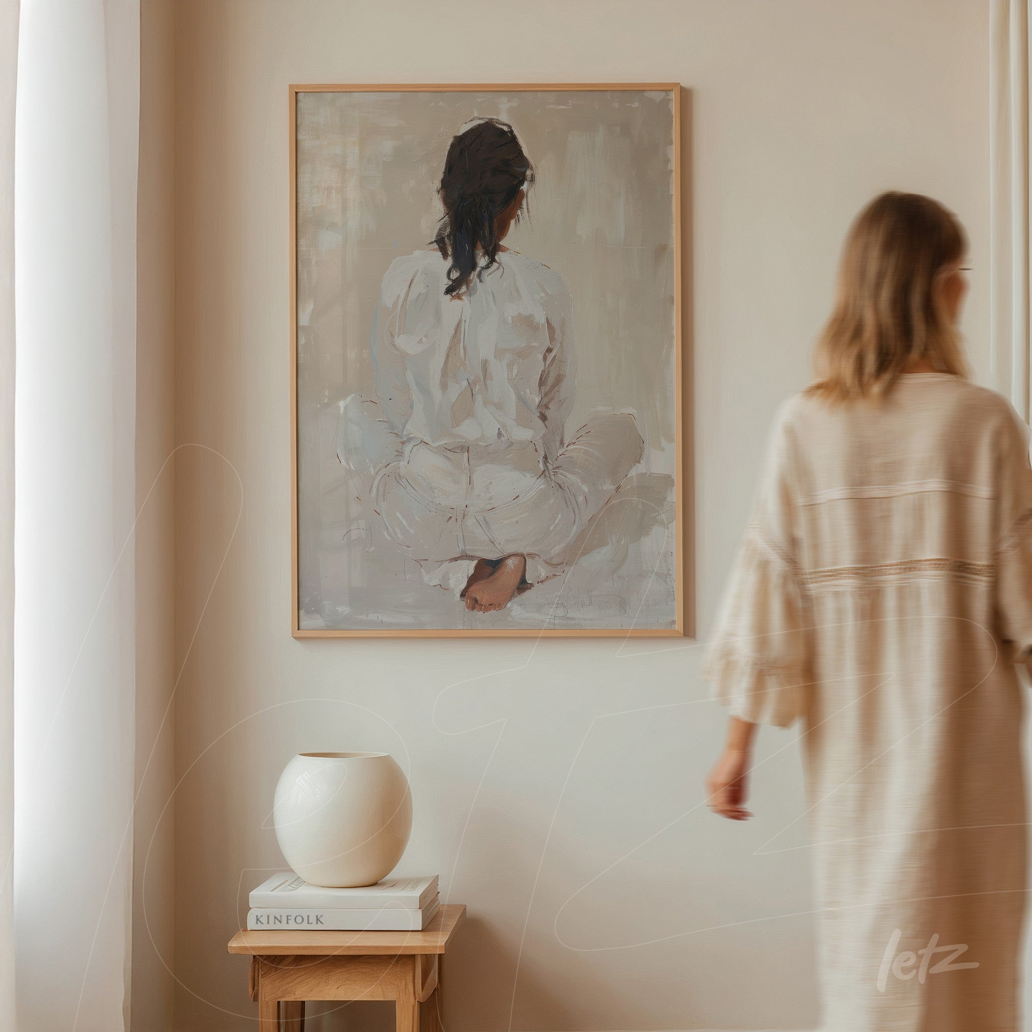 contemporary wall art depicting a seated female figure from behind in a light frame on a neutral wall