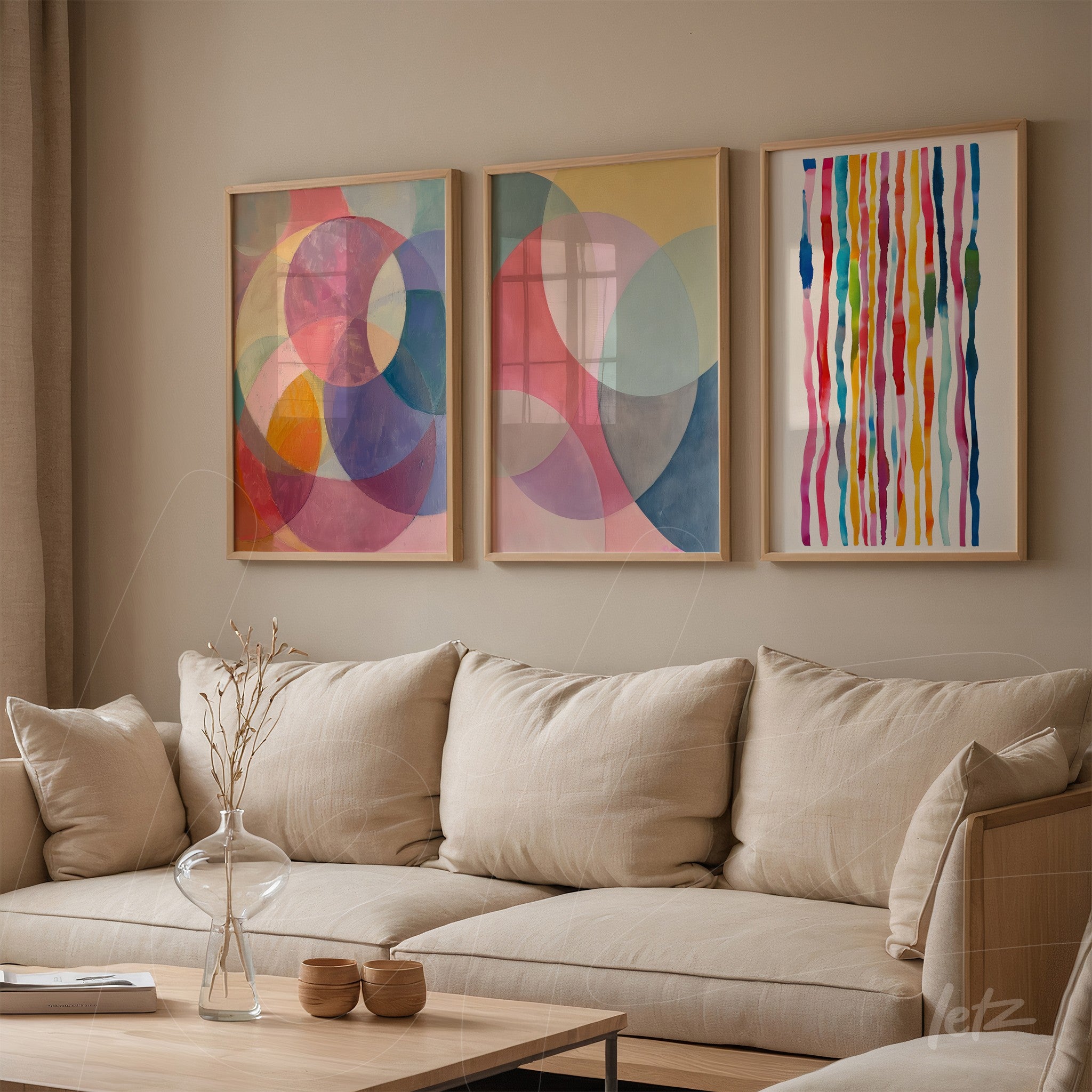 set of three framed wall artworks featuring abstract shapes in soft colors displayed above a beige sofa