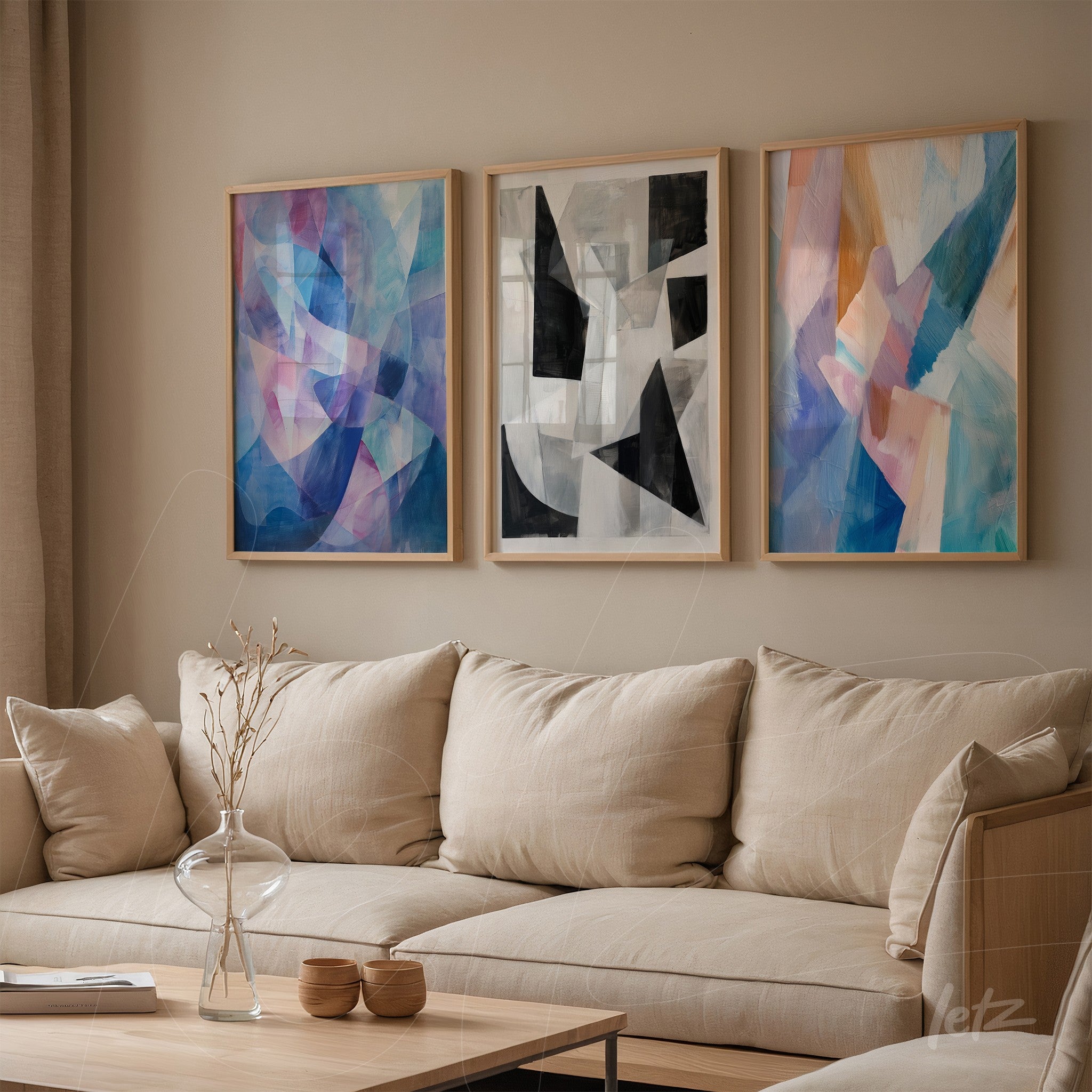 composition of three abstract framed artworks with light wood frames on neutral wall featuring geometric shapes and soft colors like blue and pink