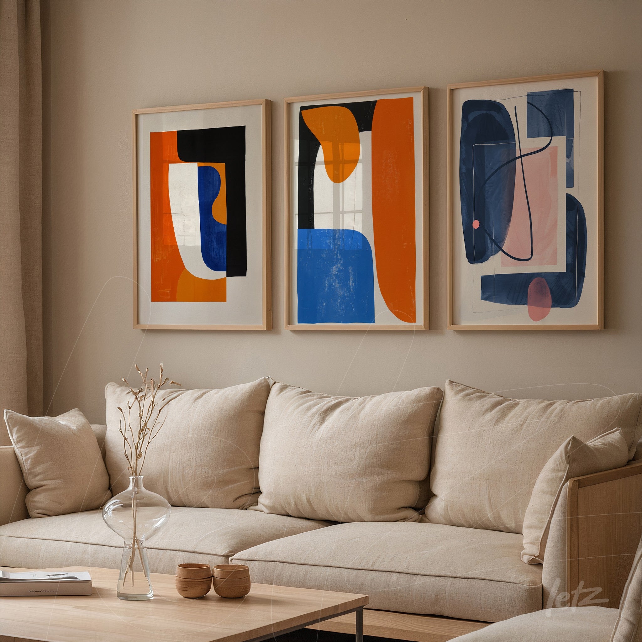 set of three framed abstract art pieces in light frames displayed above a neutral sofa in a modern living space