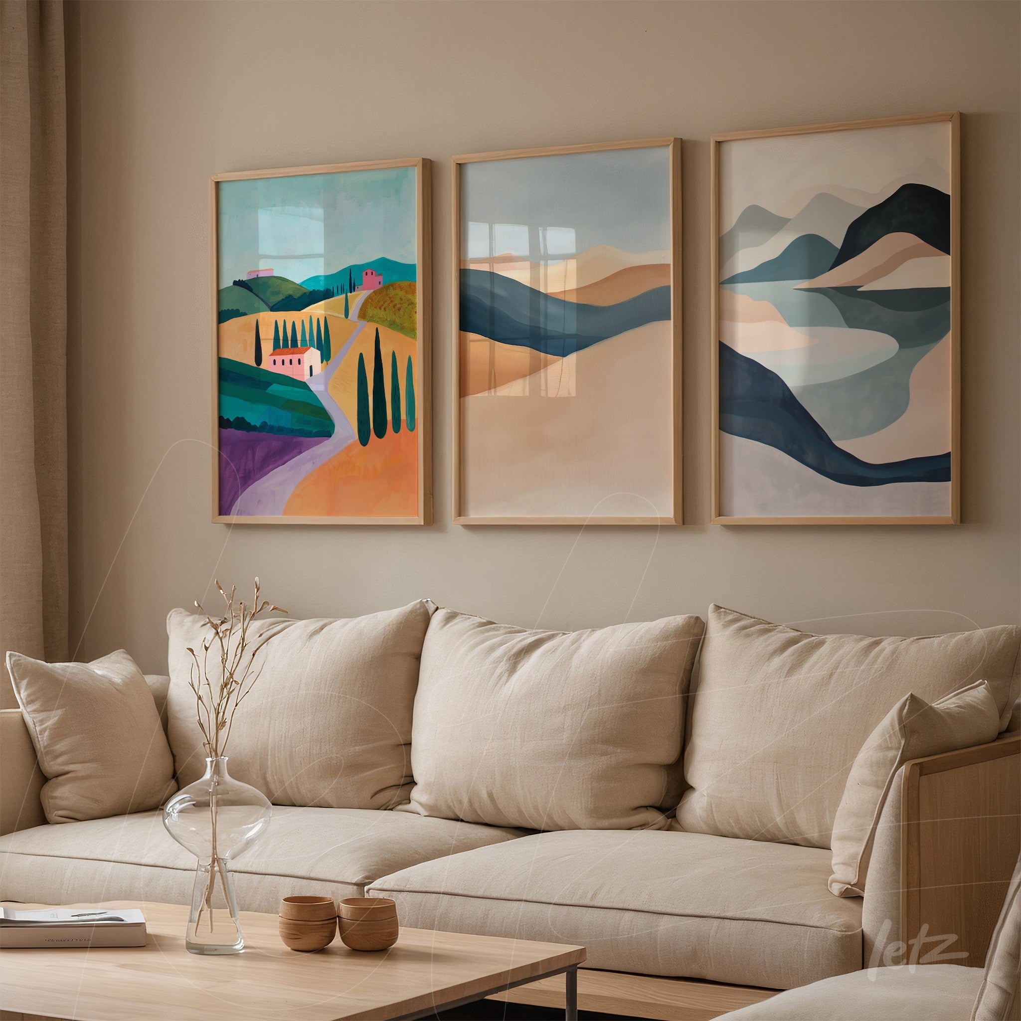 set of three framed artworks featuring colorful landscapes in light wood frames displayed on beige wall beside a neutral fabric sofa