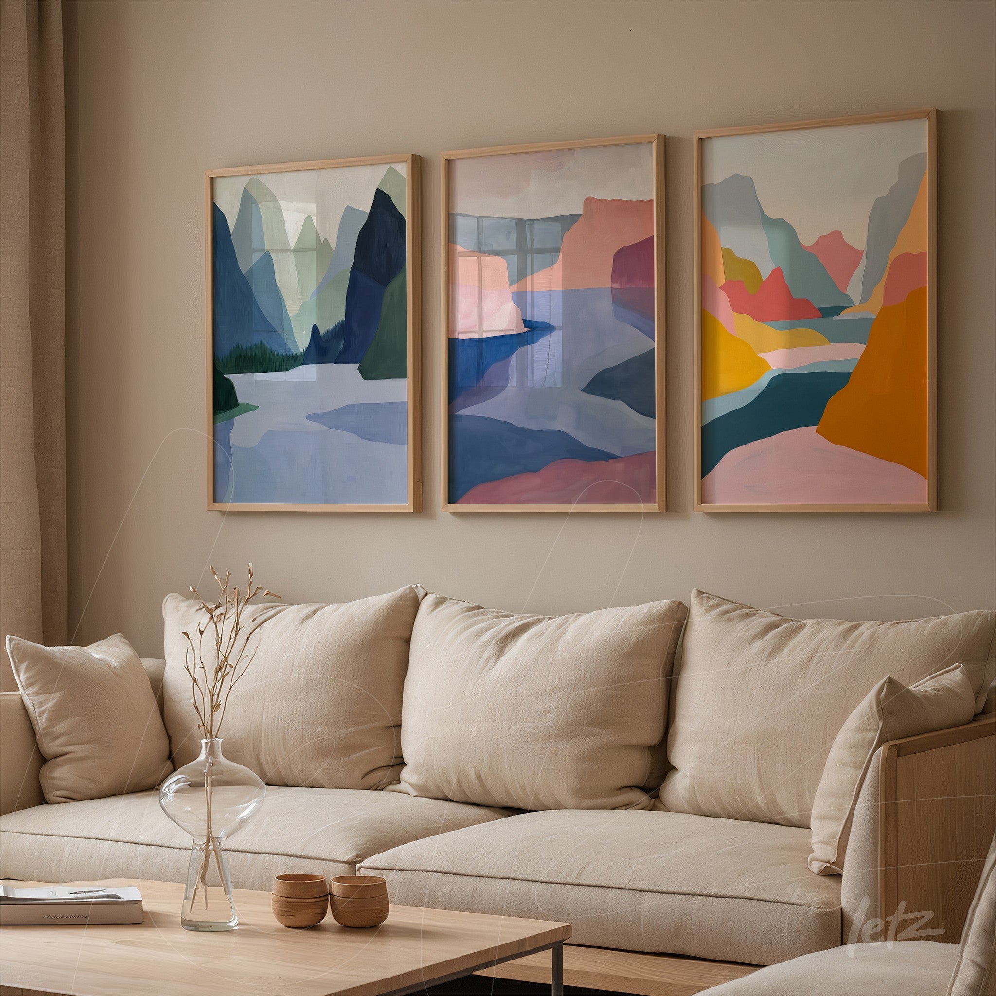 composition of three artworks featuring colorful abstractions of mountains and rivers in light wood frames displayed against a neutral wall
