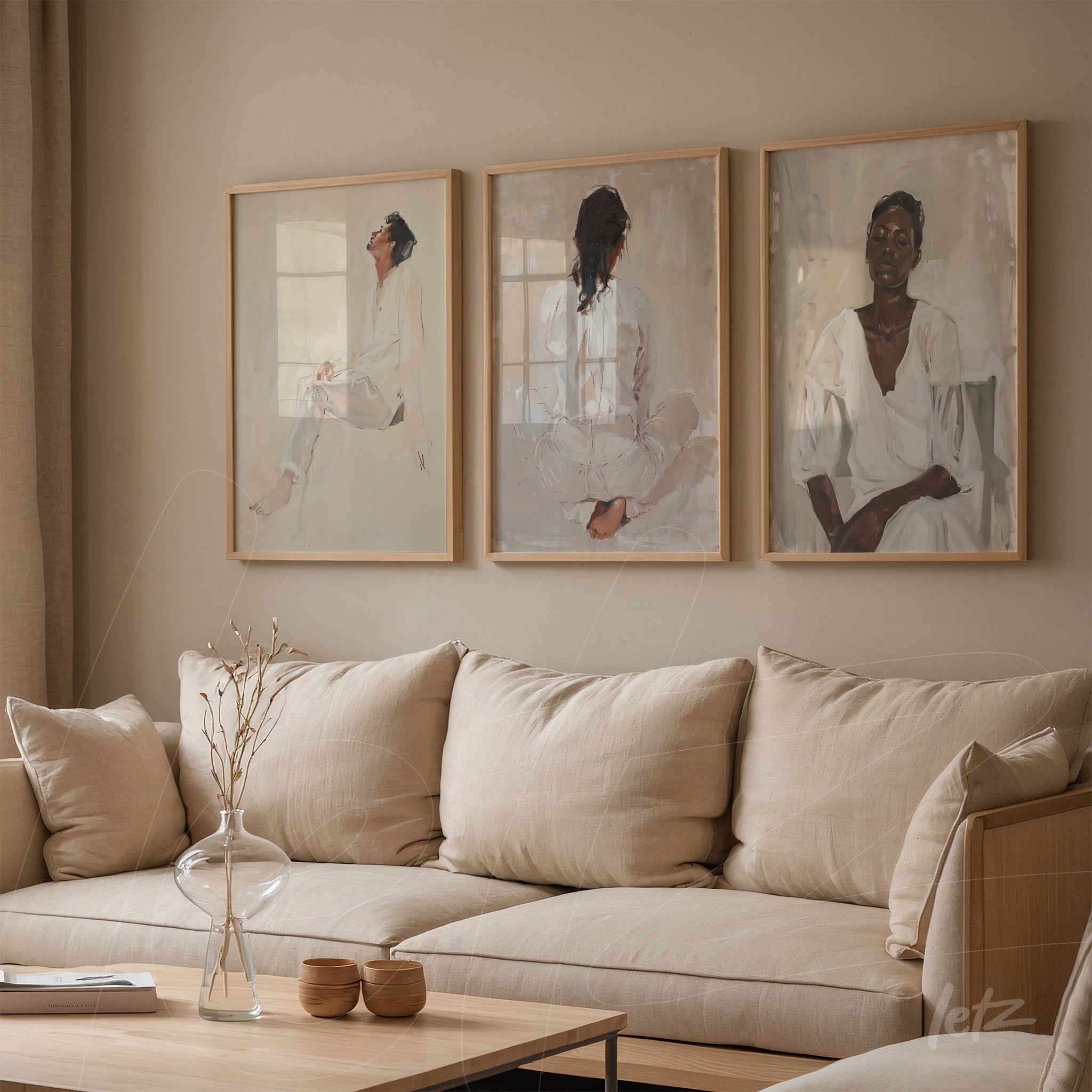 collection of three decorative wall art pieces featuring female portraits in light frames on a neutral wall above a soft-toned sofa