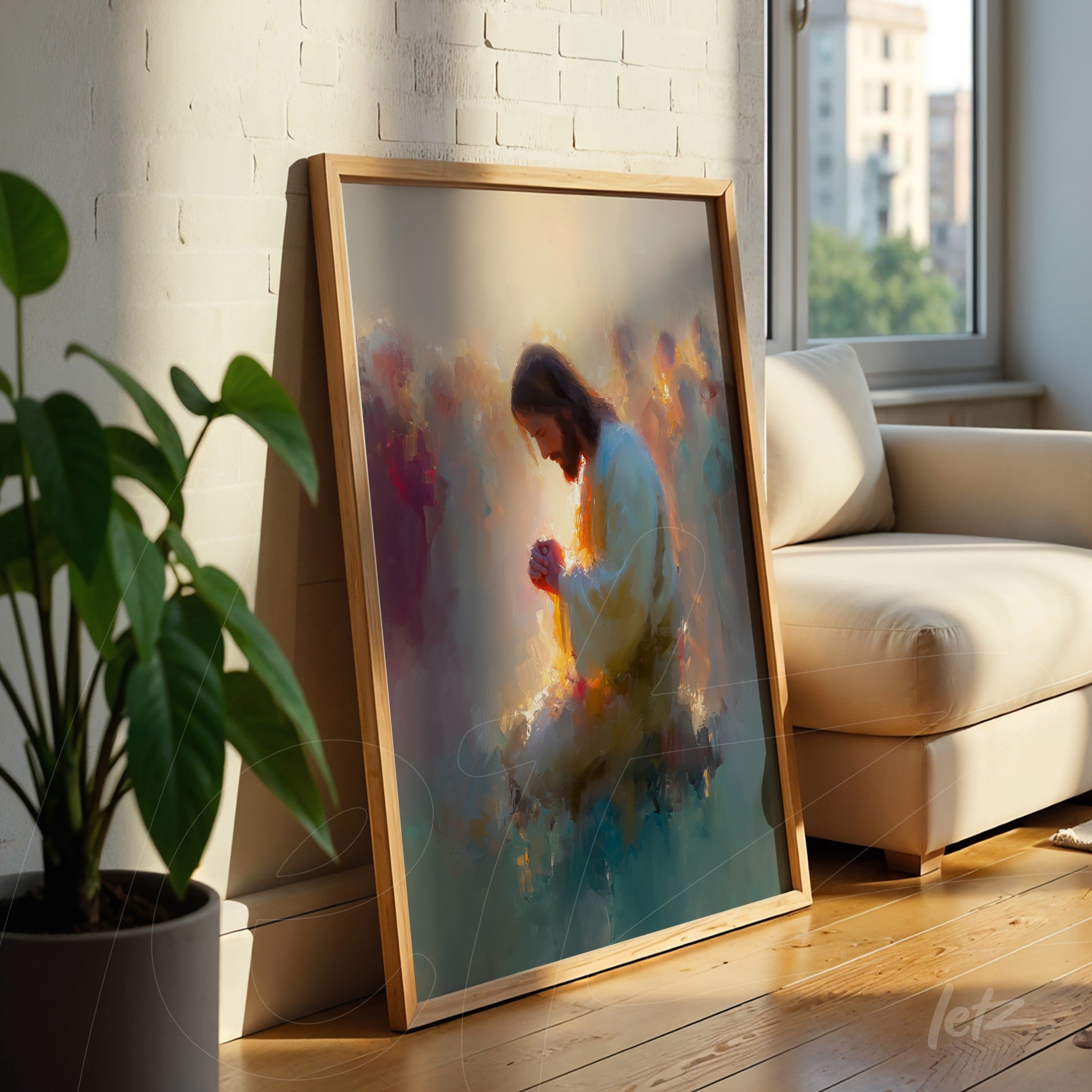 framed artwork featuring an abstract religious figure in a light wood frame, leaning against a wall beside a plant in a brightly lit setting