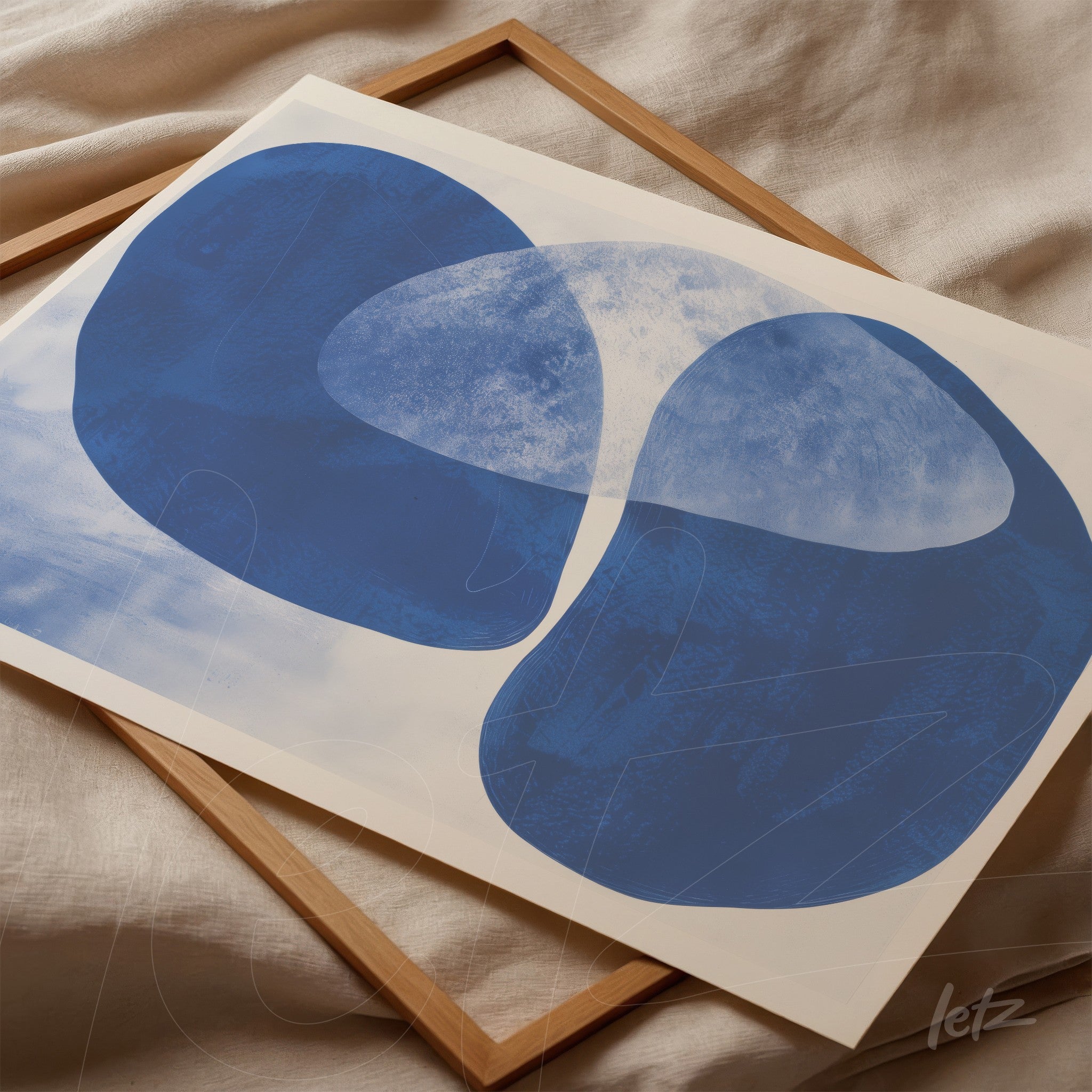 abstract wall art in shades of blue displayed in a light wood frame