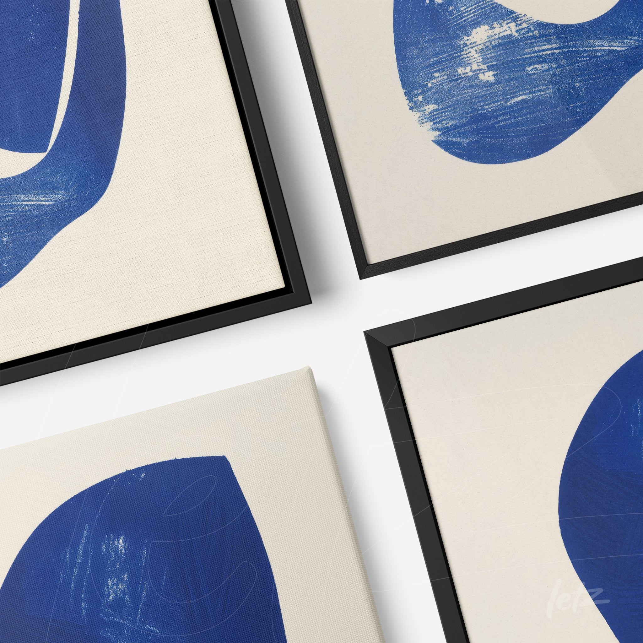 composition of framed abstract wall art in blue with black frames displayed at various angles