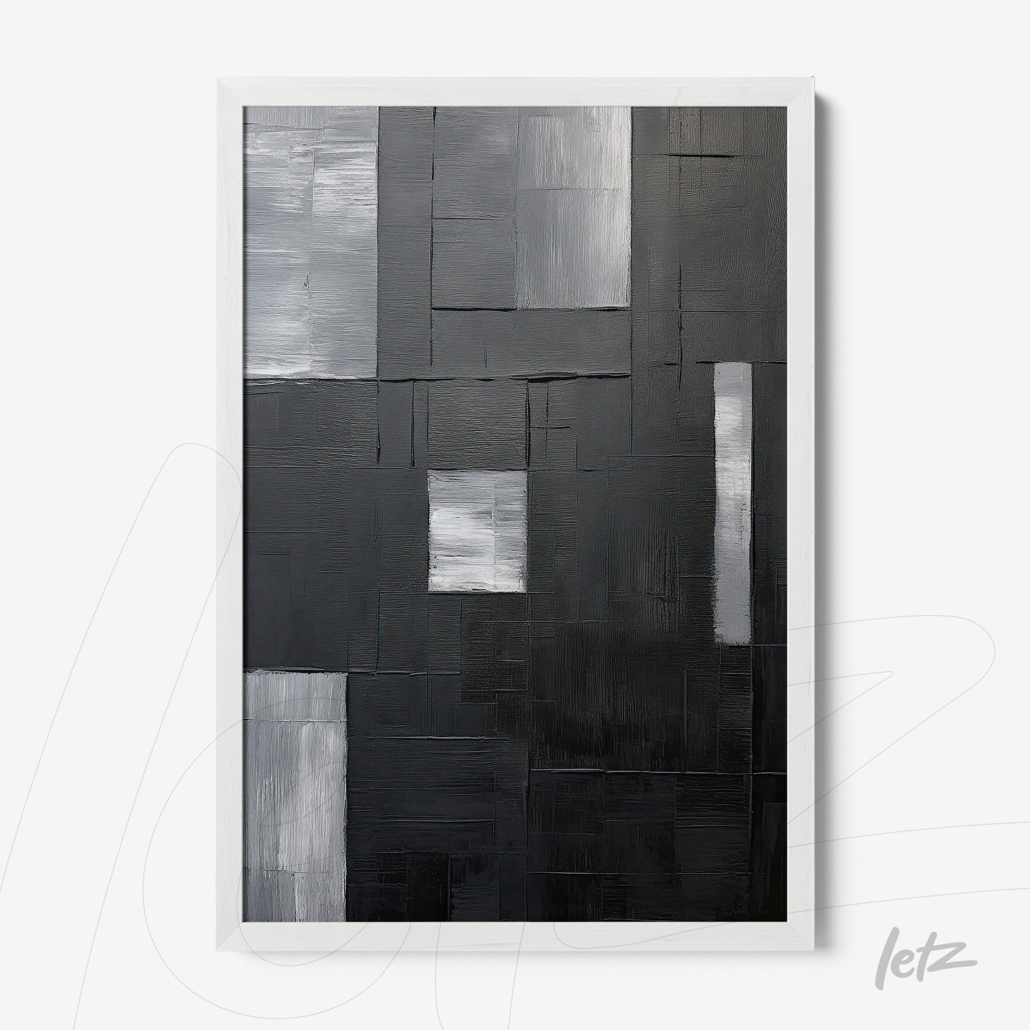 abstract wall art in shades of black, gray, and white with a white frame