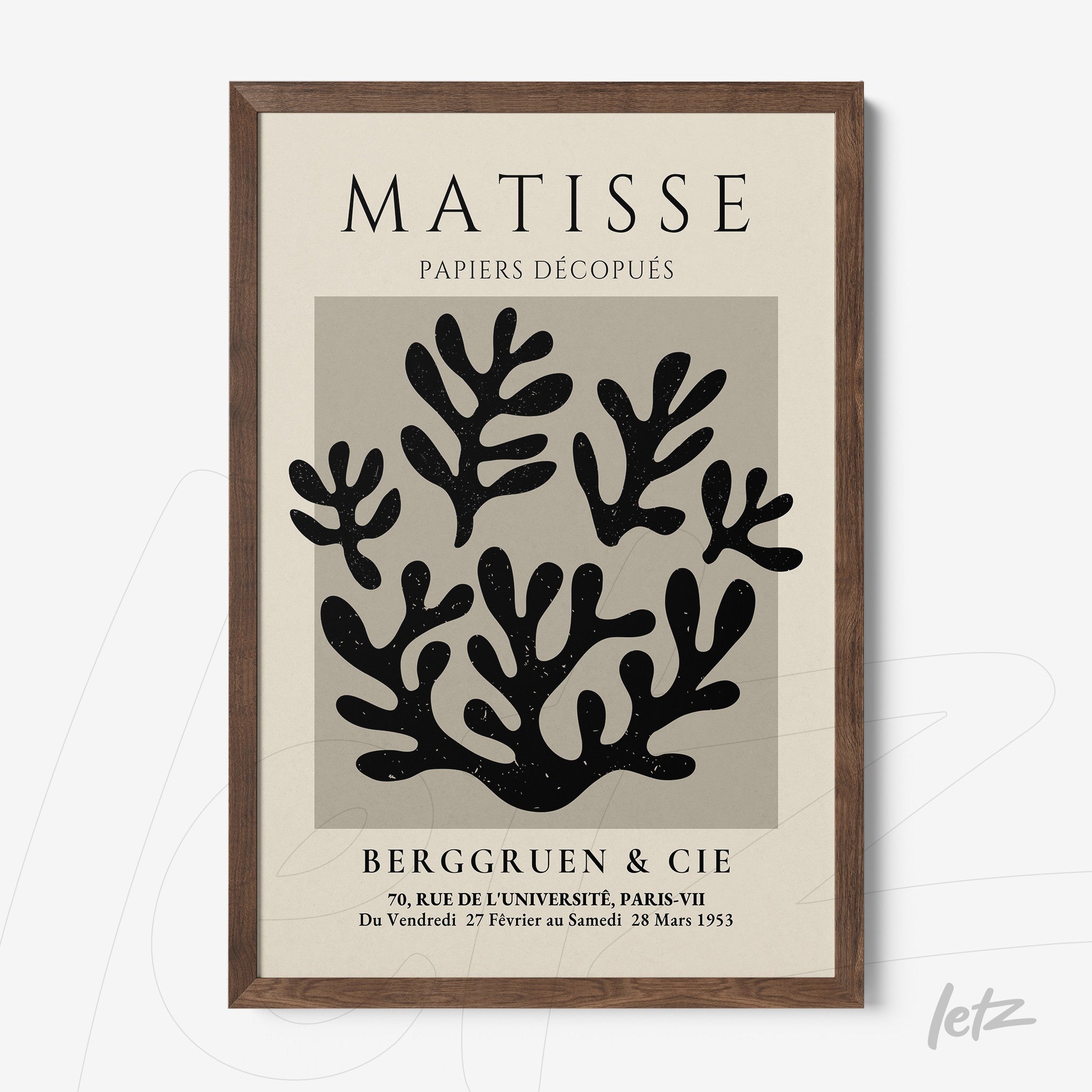 framed wall art featuring modern paper cutouts in shades of black with a dark wood frame and light gray background