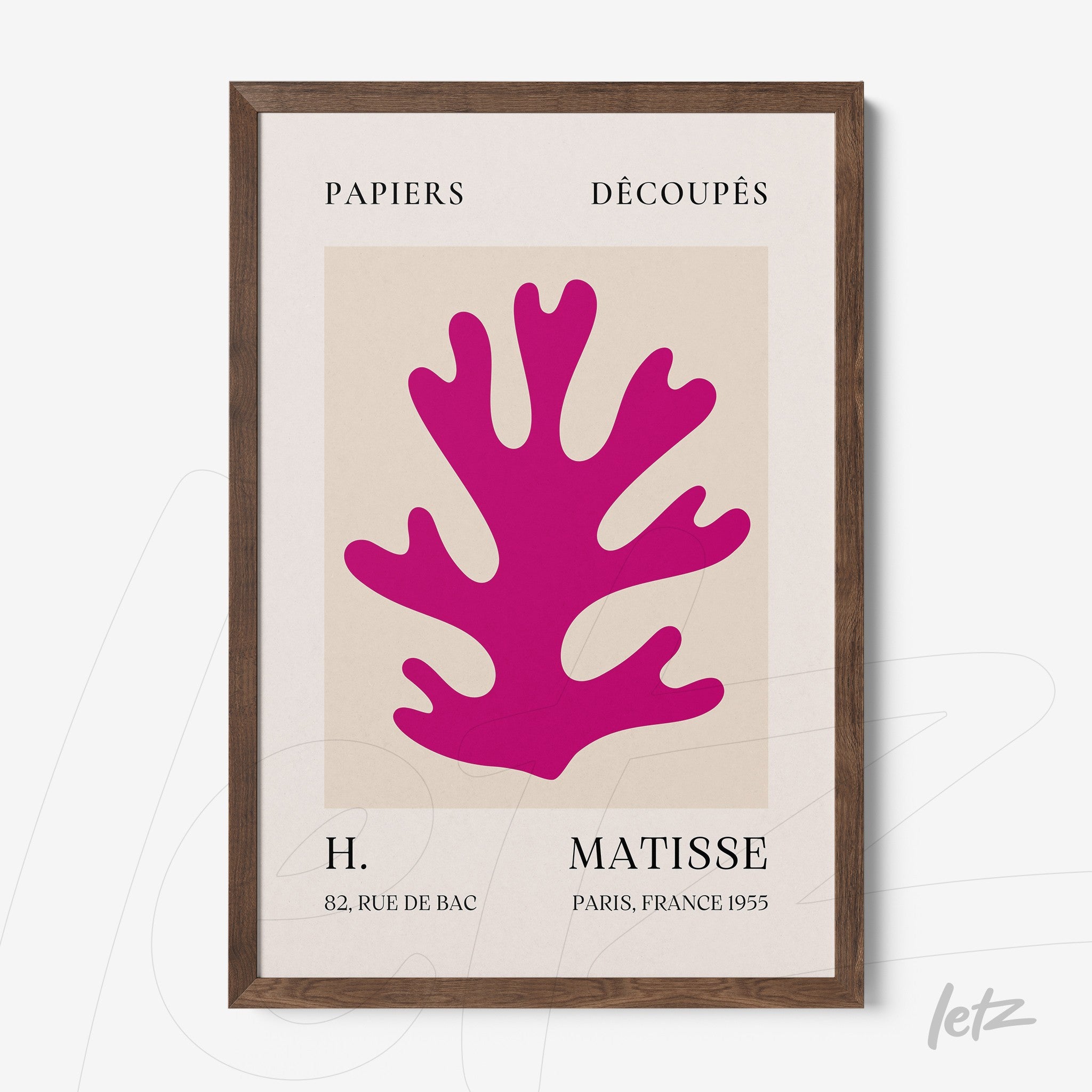 framed wall art with vibrant pink cut paper design against a neutral background in a light wood frame