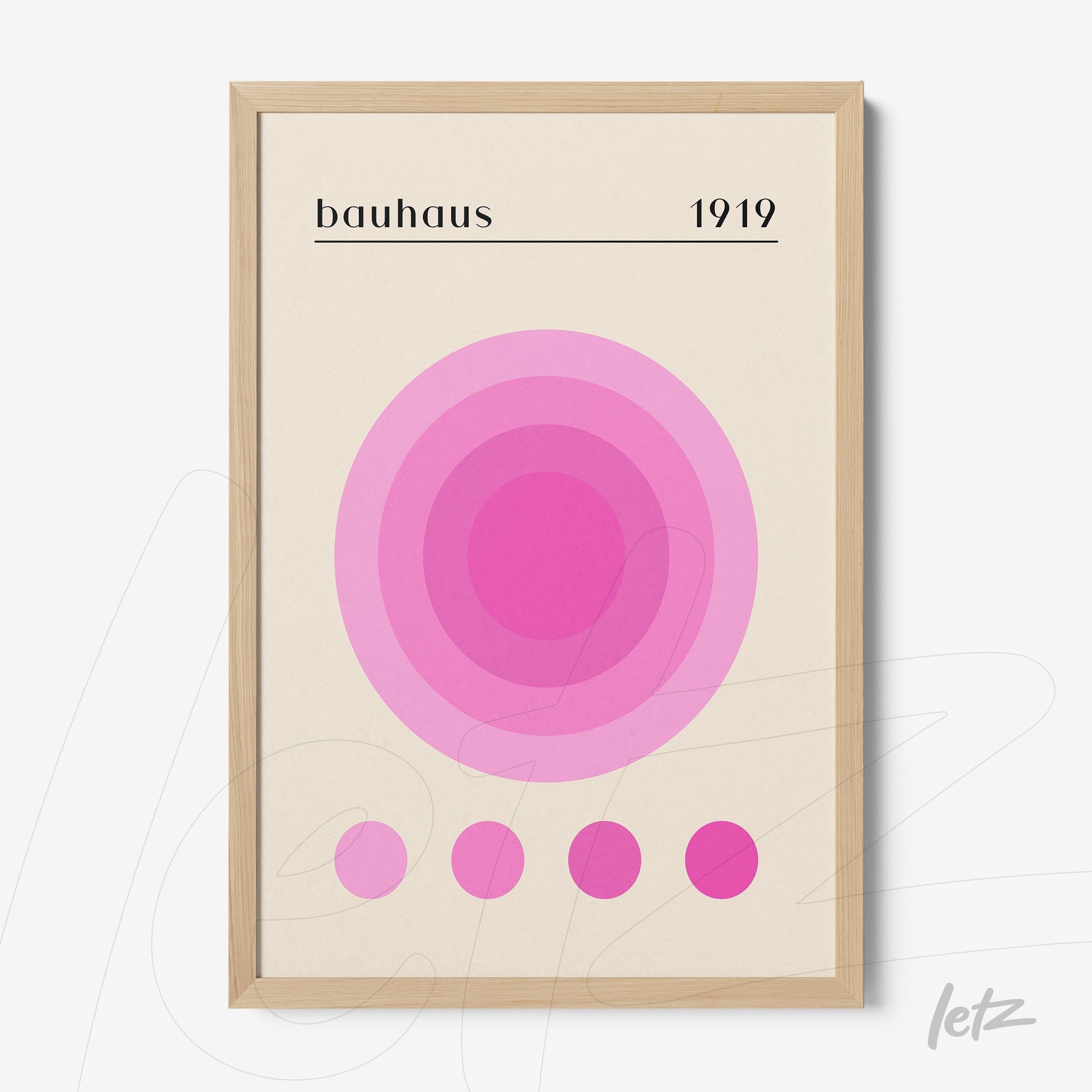 poster print of geometric bauhaus style art in shades of pink with a narrow light wood frame