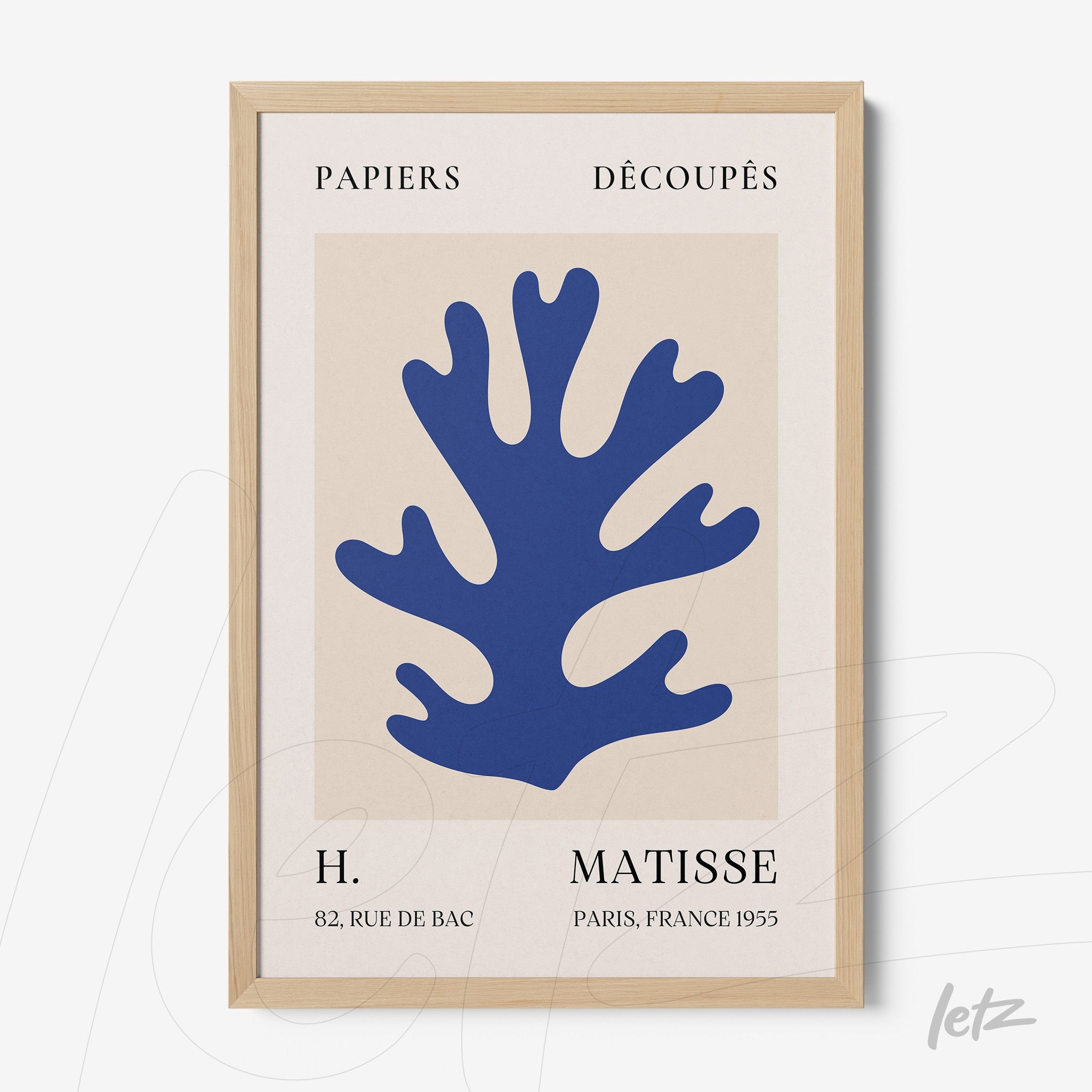 modern framed artwork featuring paper cutout of a blue coral on a neutral background with light wooden frame