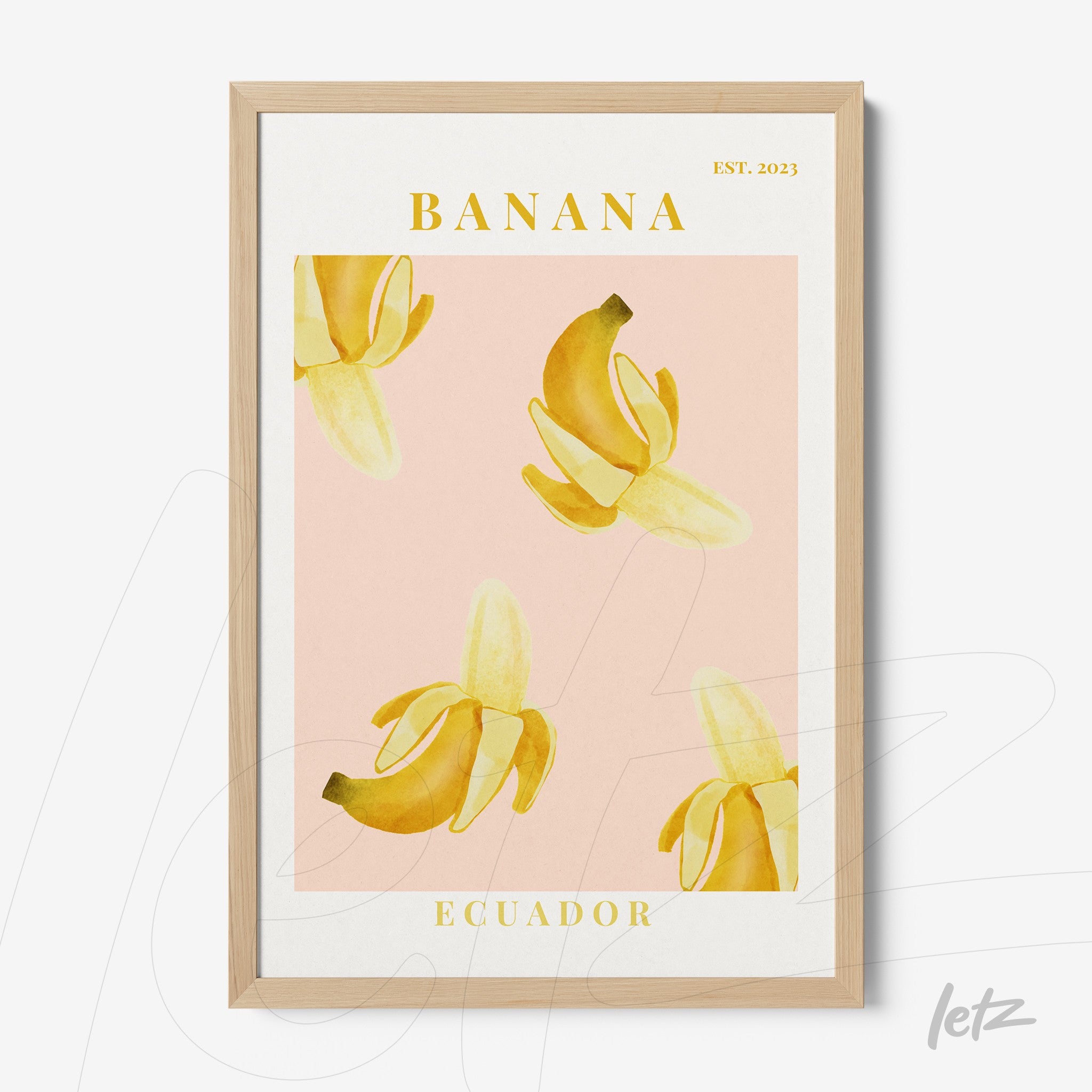 framed artwork featuring bananas on pink background with light wooden frame