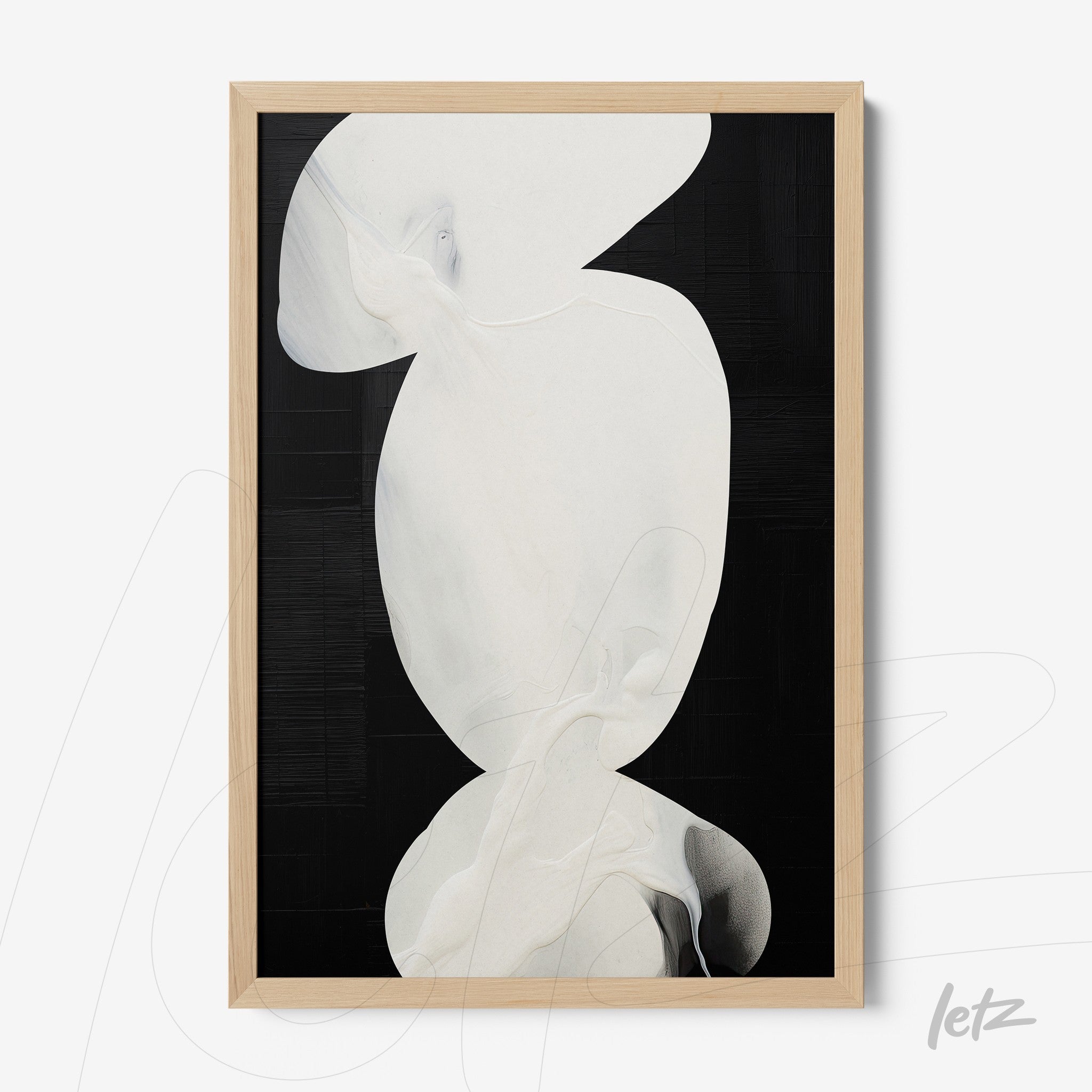 framed abstract art on black background featuring white organic shapes with light wood frame