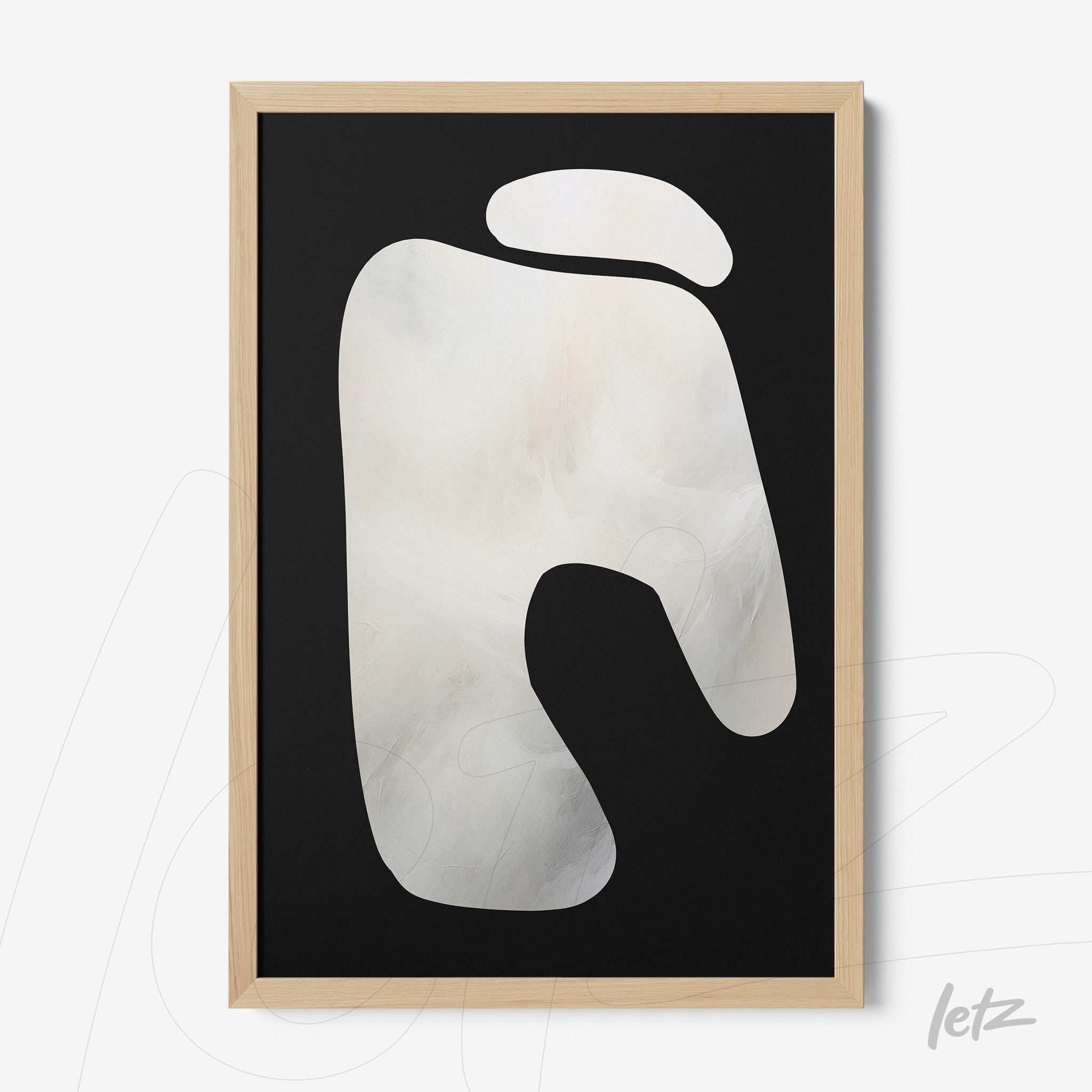 abstract wall art with white shape on black background in light wood frame