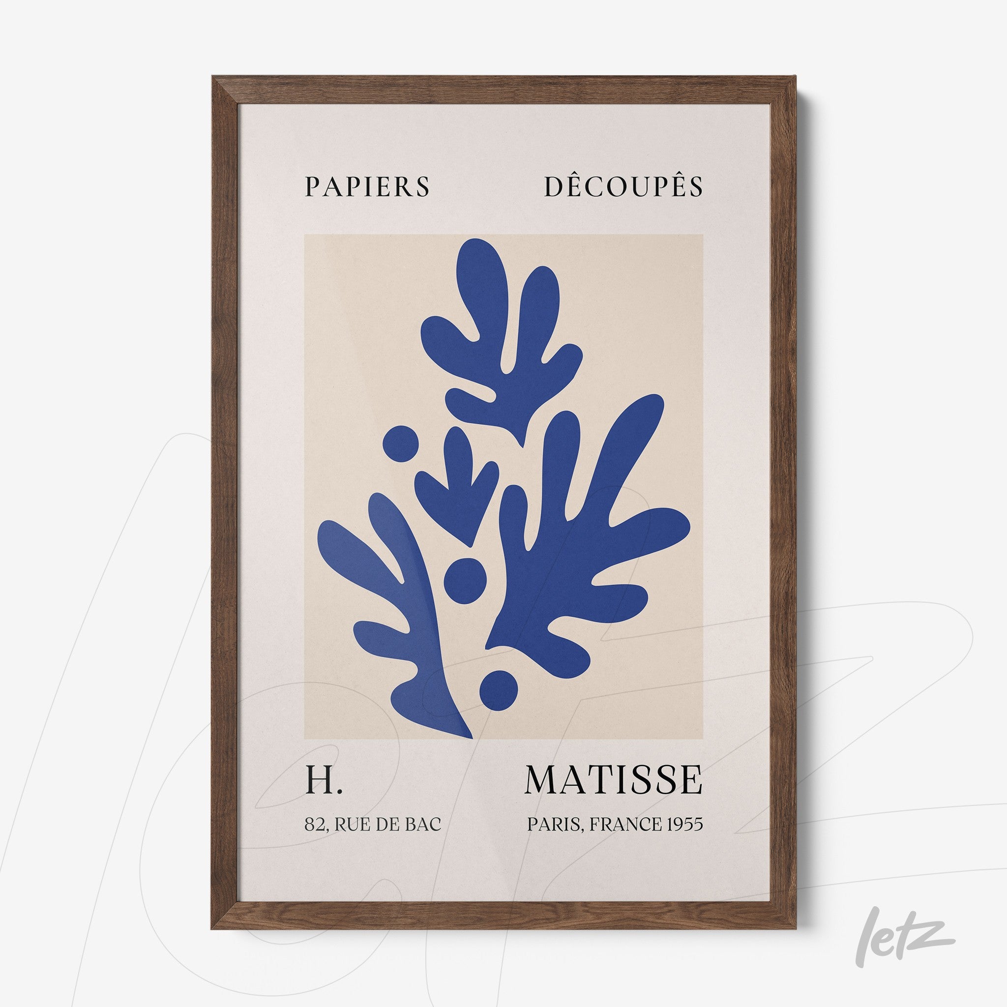 framed wall art featuring abstract blue paper cutouts on a light background with dark wooden frame