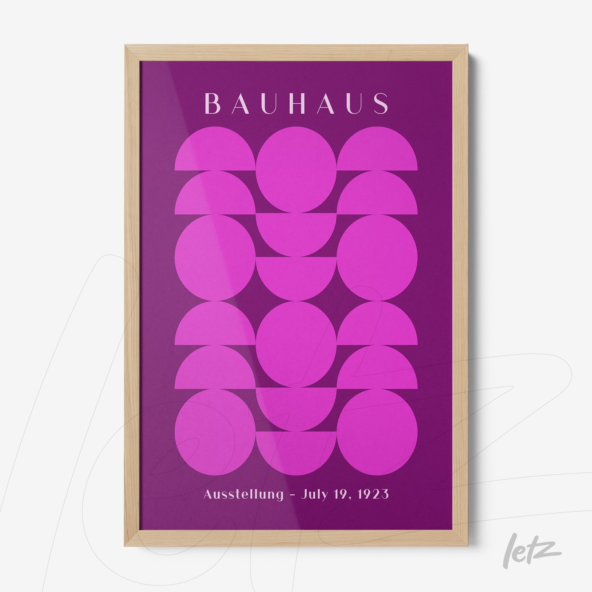 poster print featuring geometric pink shapes on a purple background with light wood frame