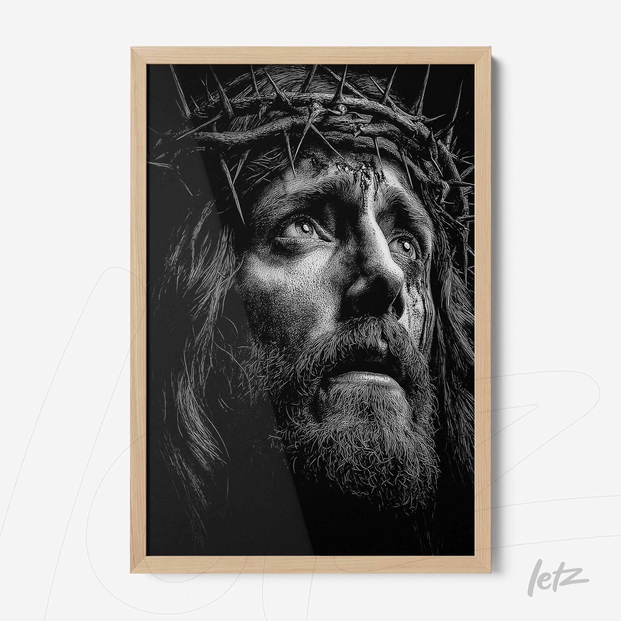 framed black and white portrait of a man with a crown of thorns in light wood frame