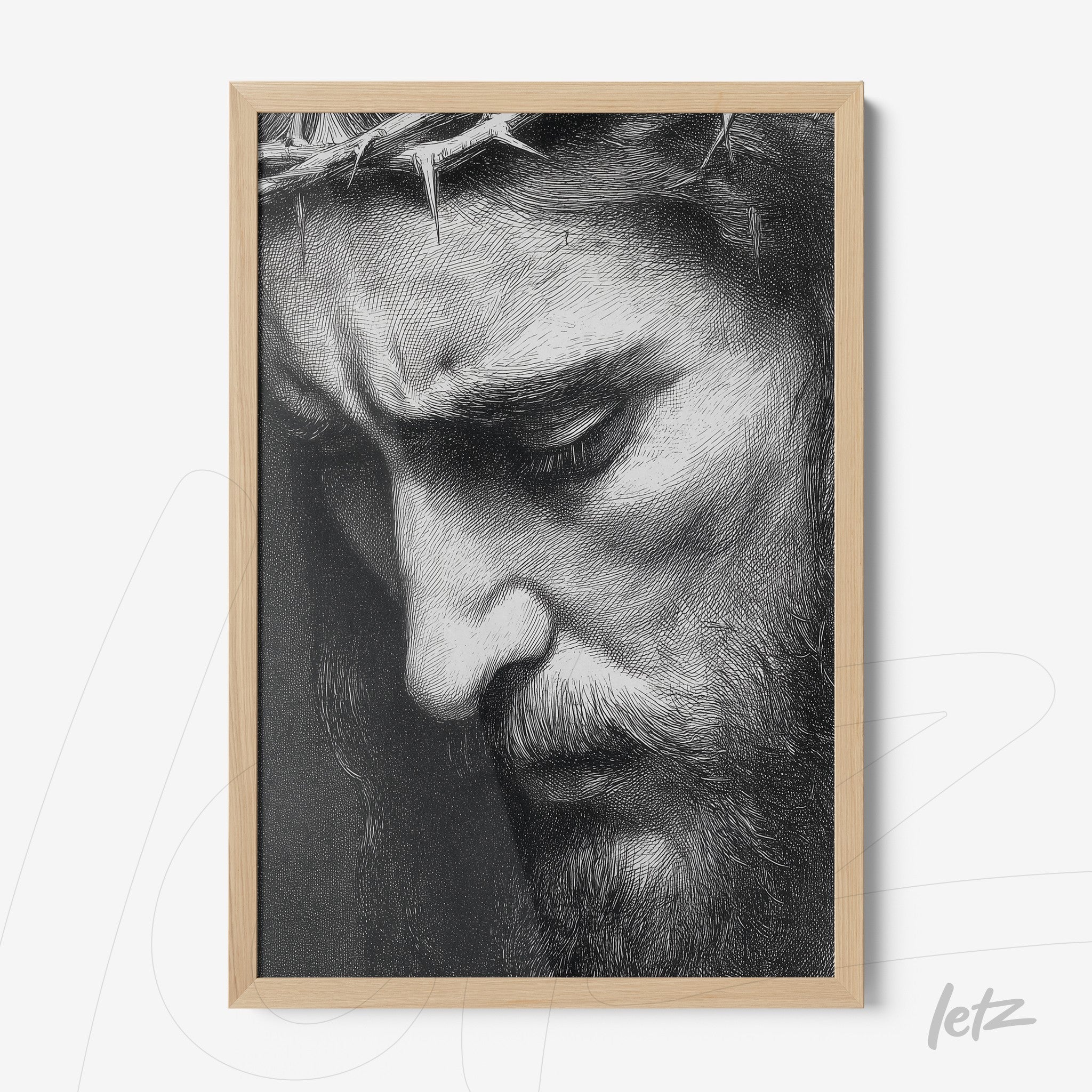 framed artwork in light wood depicting a black and white close-up of Christ's face expressing pain