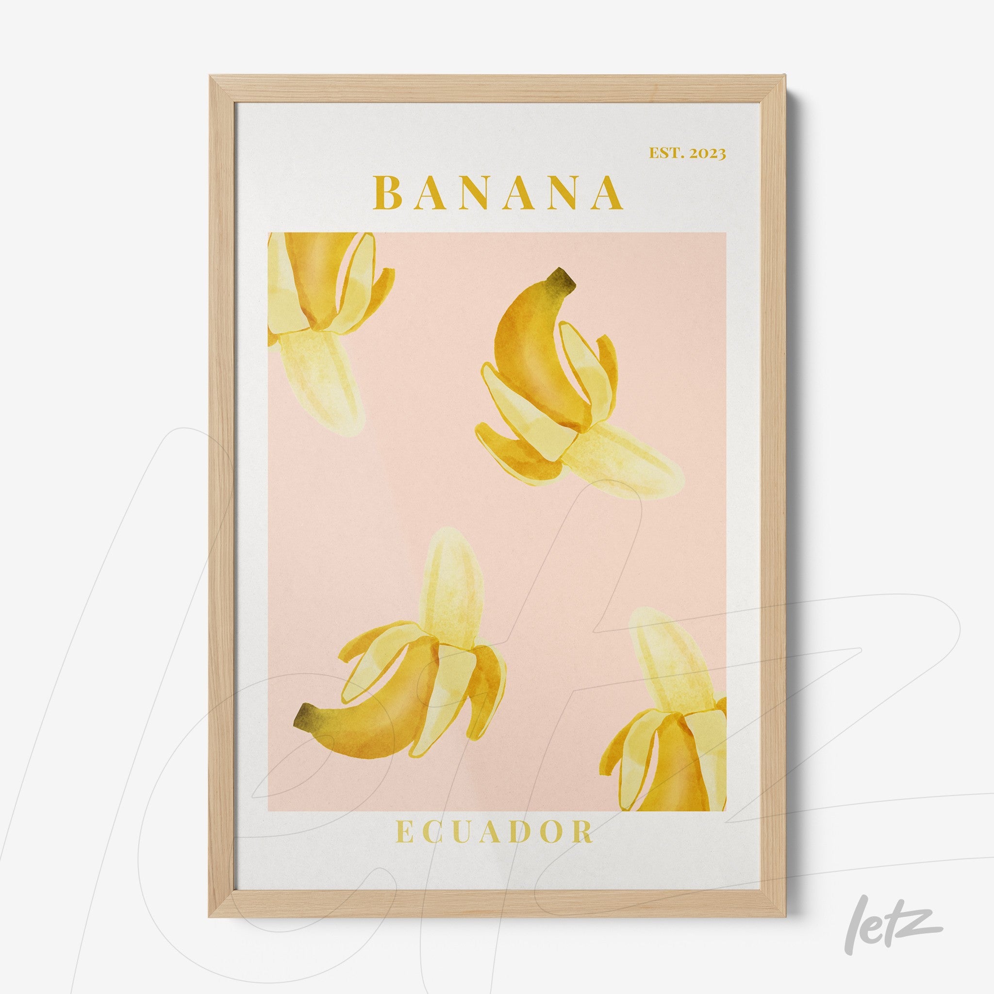 framed wall art featuring yellow bananas on a pink background with light wood frame and text 'BANANA ECUADOR EST. 2023'