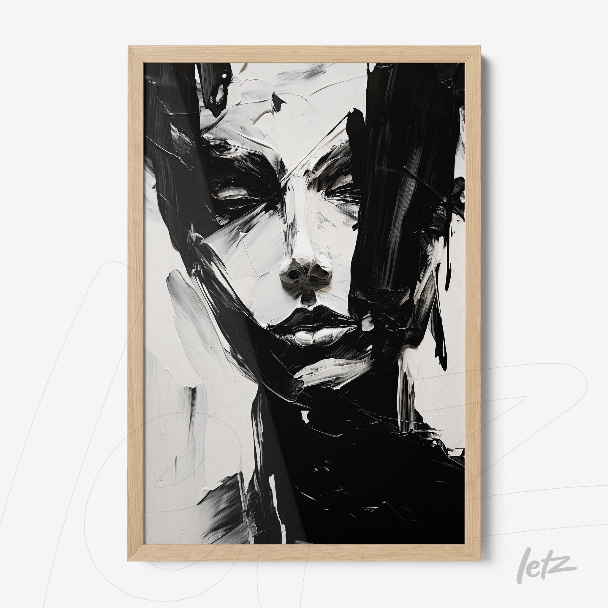 framed wall art featuring an abstract black and white portrait in light wood frame