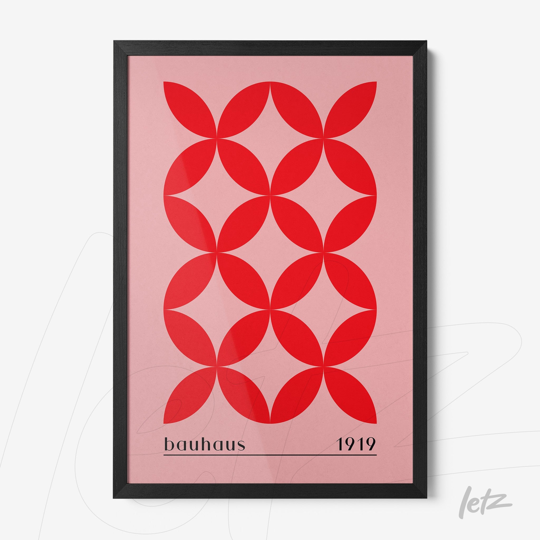 modern geometric poster print with red circular shapes on a pink background in a black frame