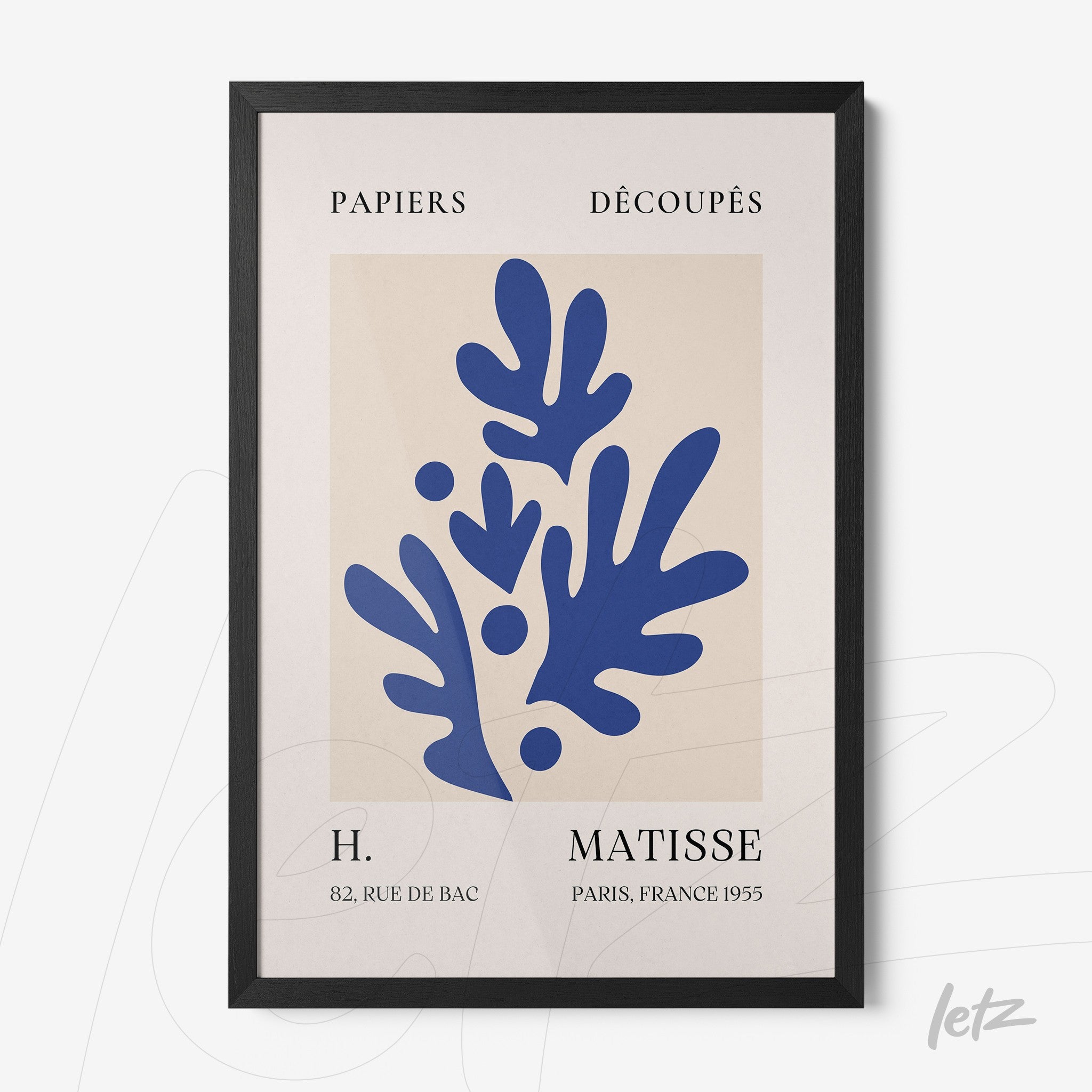 decorative wall art featuring cut-out leaf shapes in blue on light background framed in black