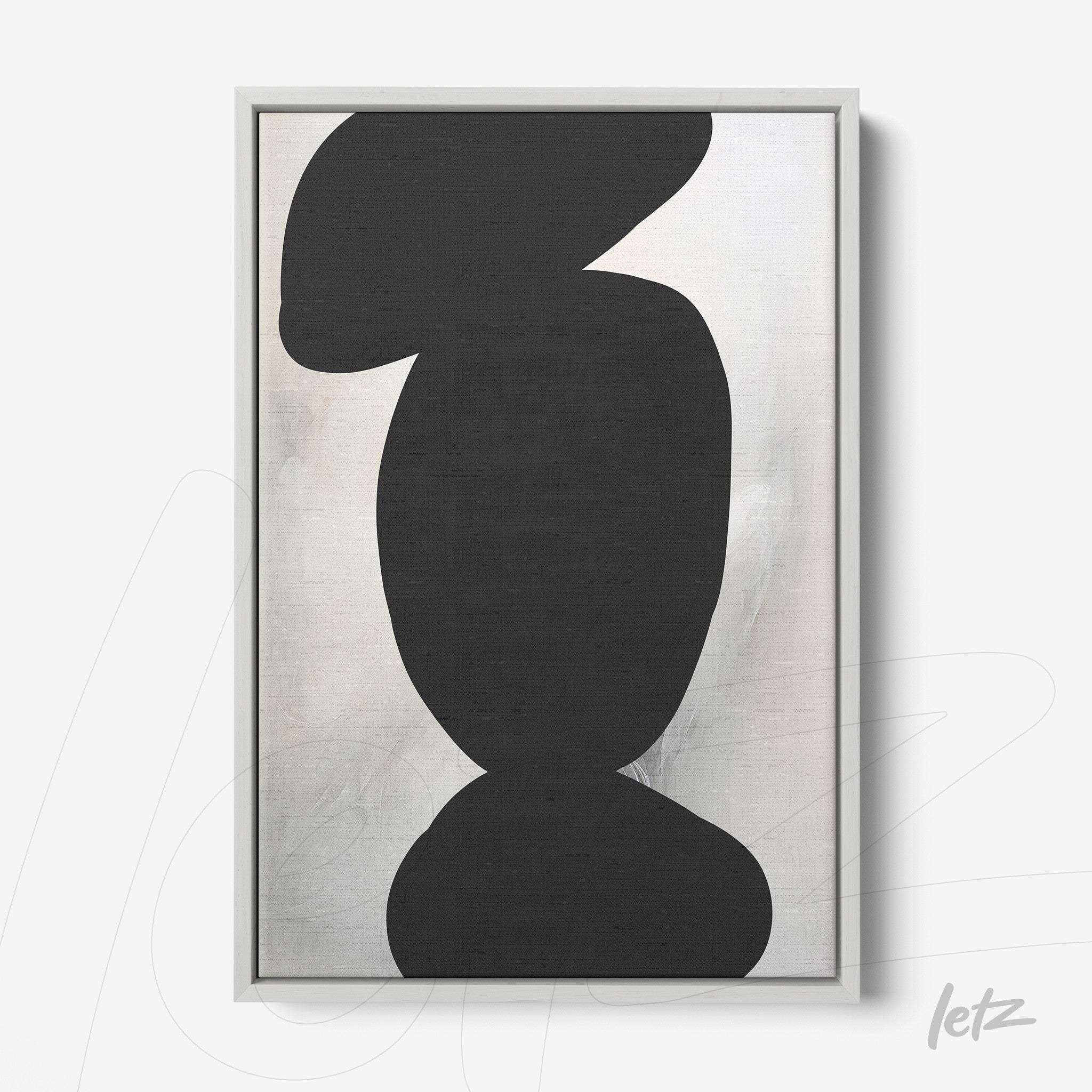 framed abstract art with black shapes on a light background and a silver frame