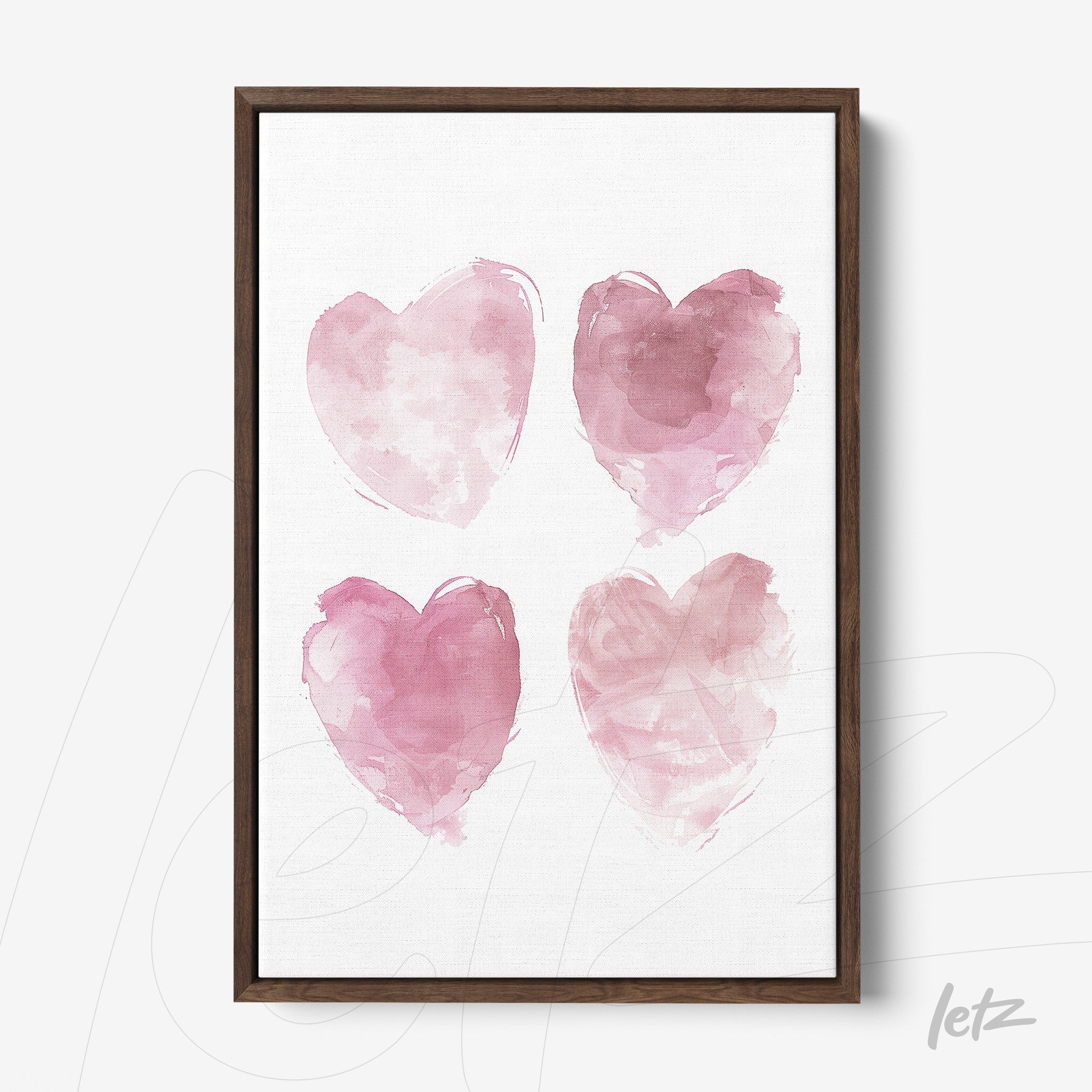framed art featuring four pink watercolor hearts on a white background with a dark wood frame