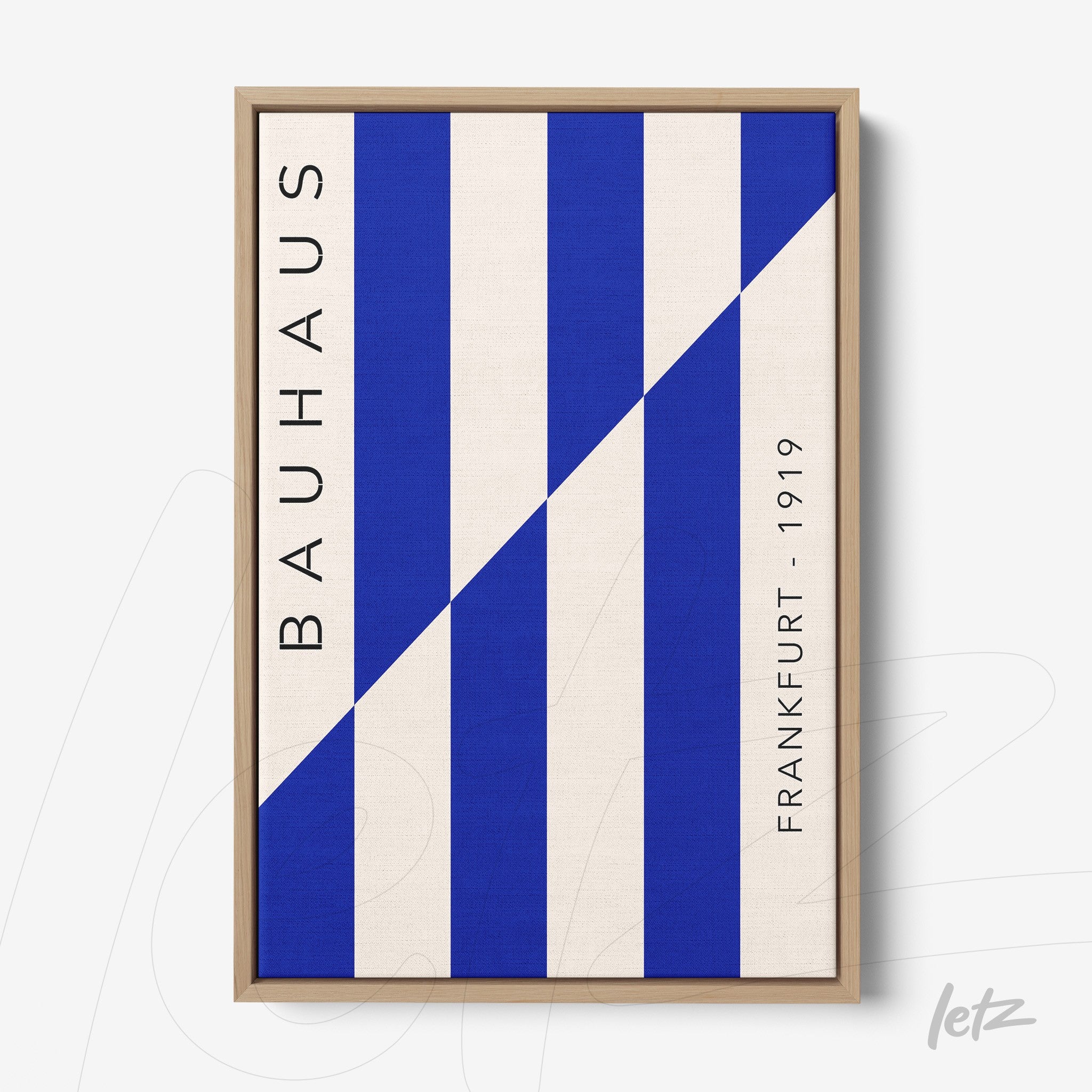 canvas print with geometric blue patterns and vertical text bauhaus frankfurt 1919 in light wood frame