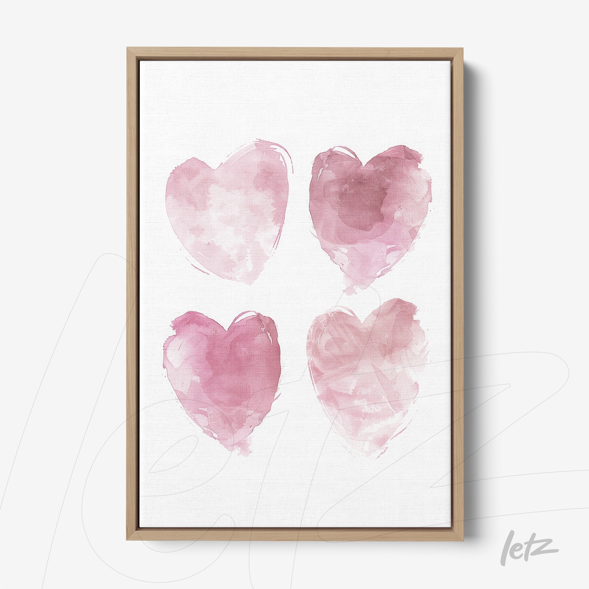 framed wall art featuring four pink watercolor hearts in light wood frame
