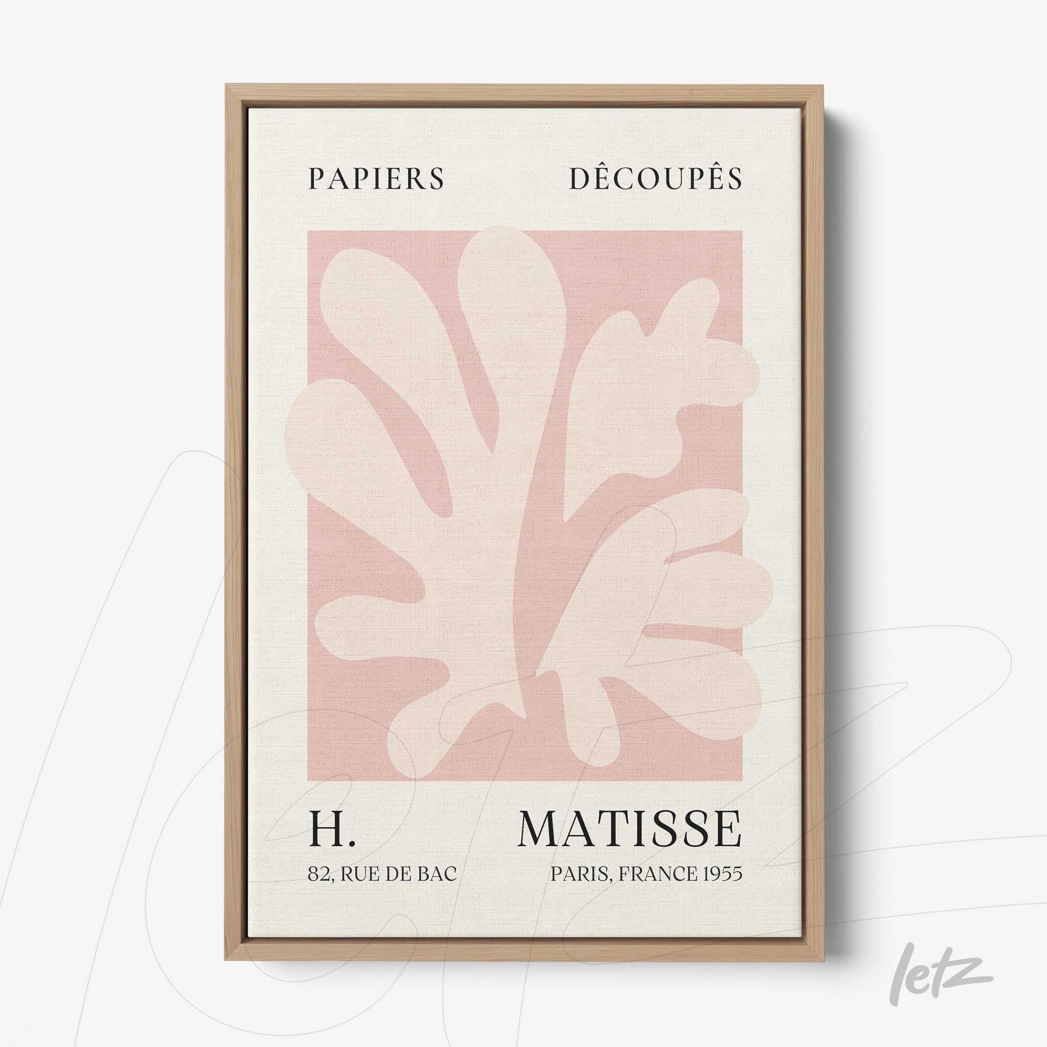 framed wall art featuring abstract shapes in pink and cream with light wood frame