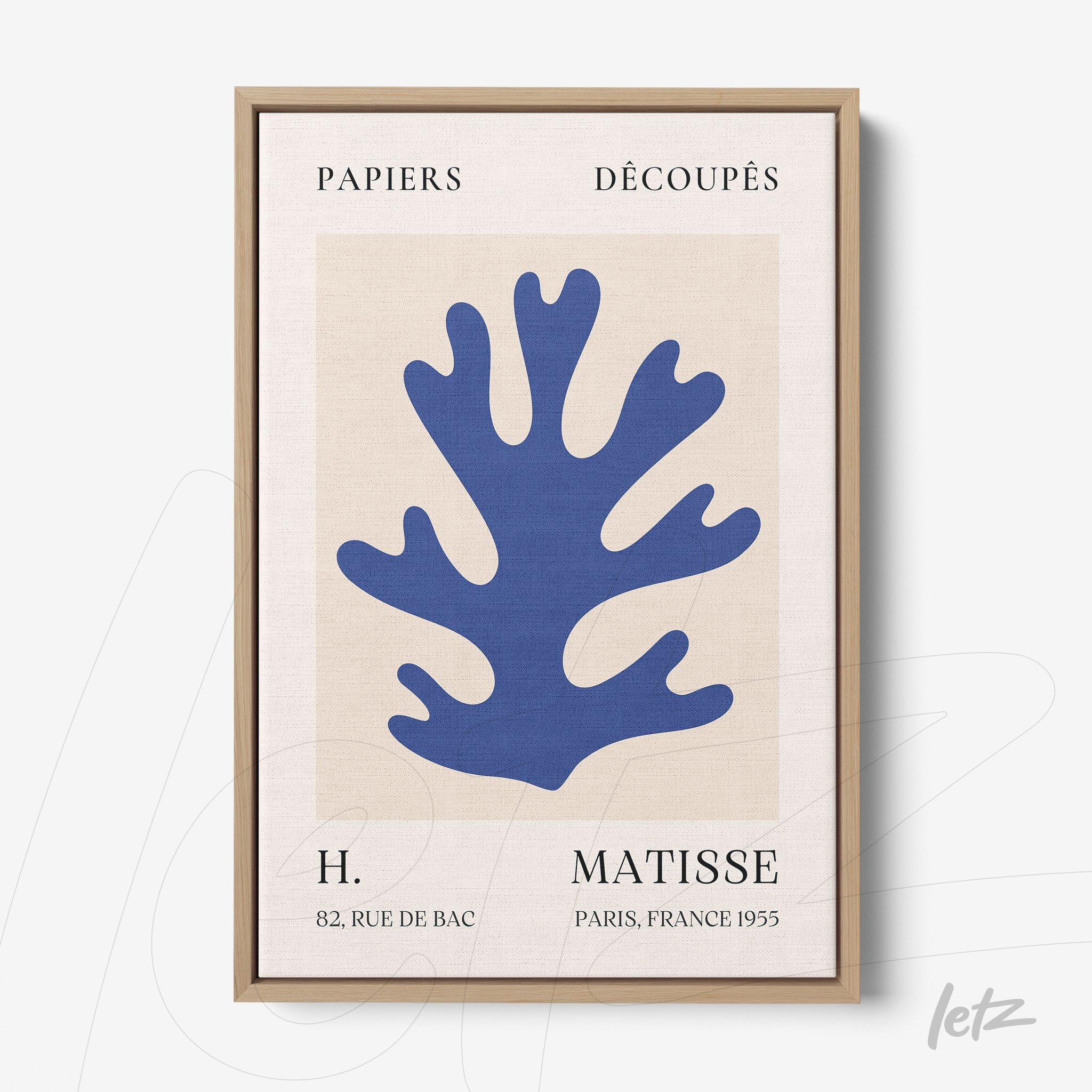 framed abstract art of blue coral on a light background with vintage text details and a light wooden frame