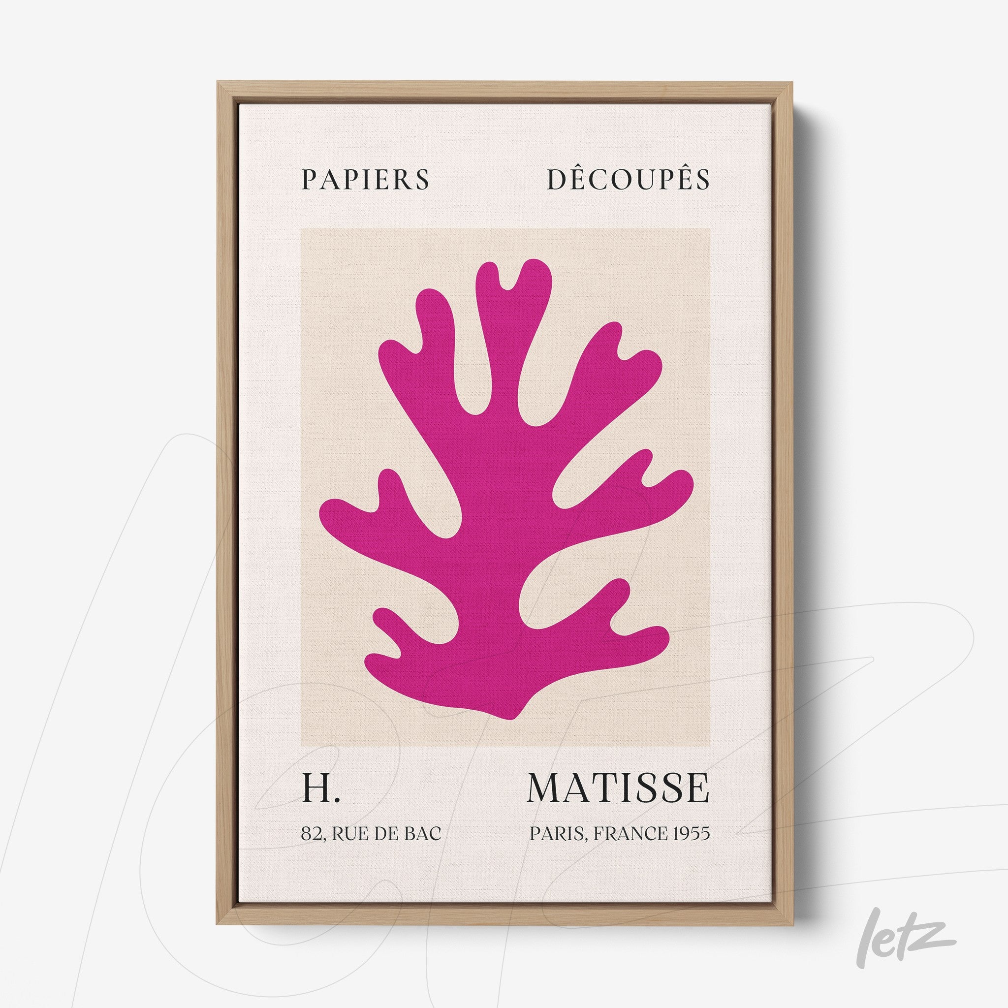 canvas wall art featuring colorful cutout design in pink, framed in light wood with neutral background