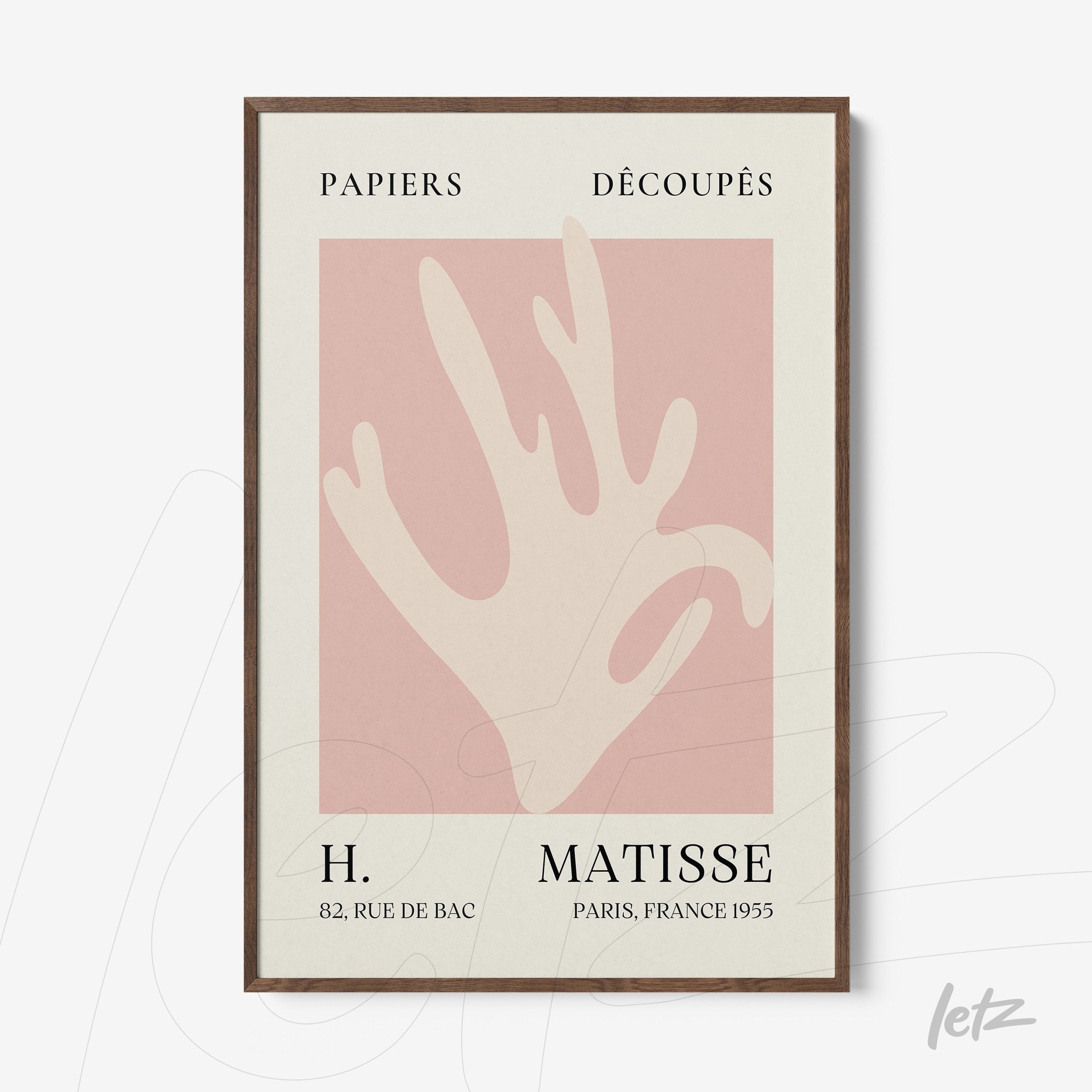 framed wall art featuring a stylized hand on light pink background with dark wood frame